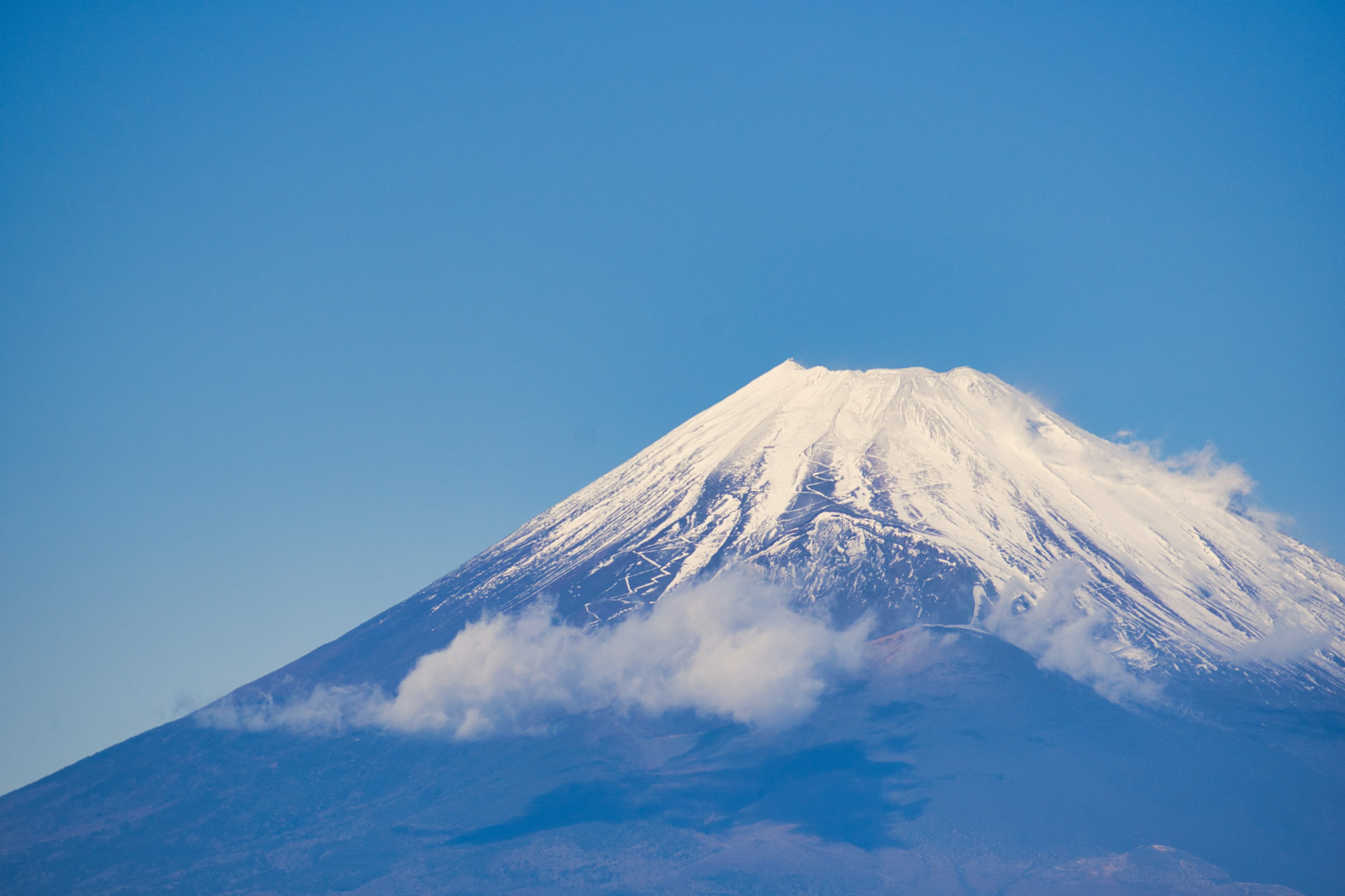 Cima innevata del monte Fuji contro un cielo blu chiaro