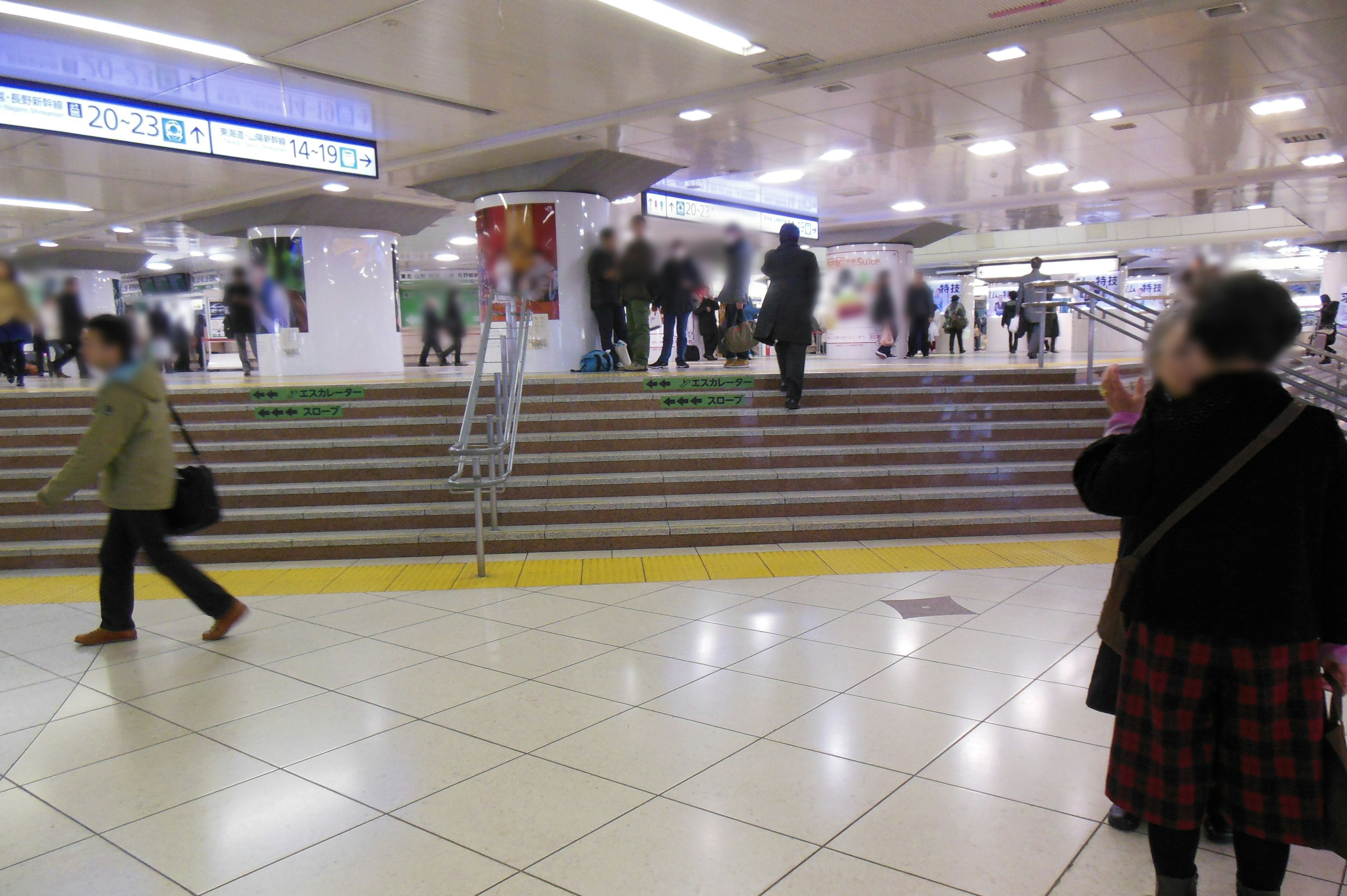 Interior of a train station with people moving and visible stairs