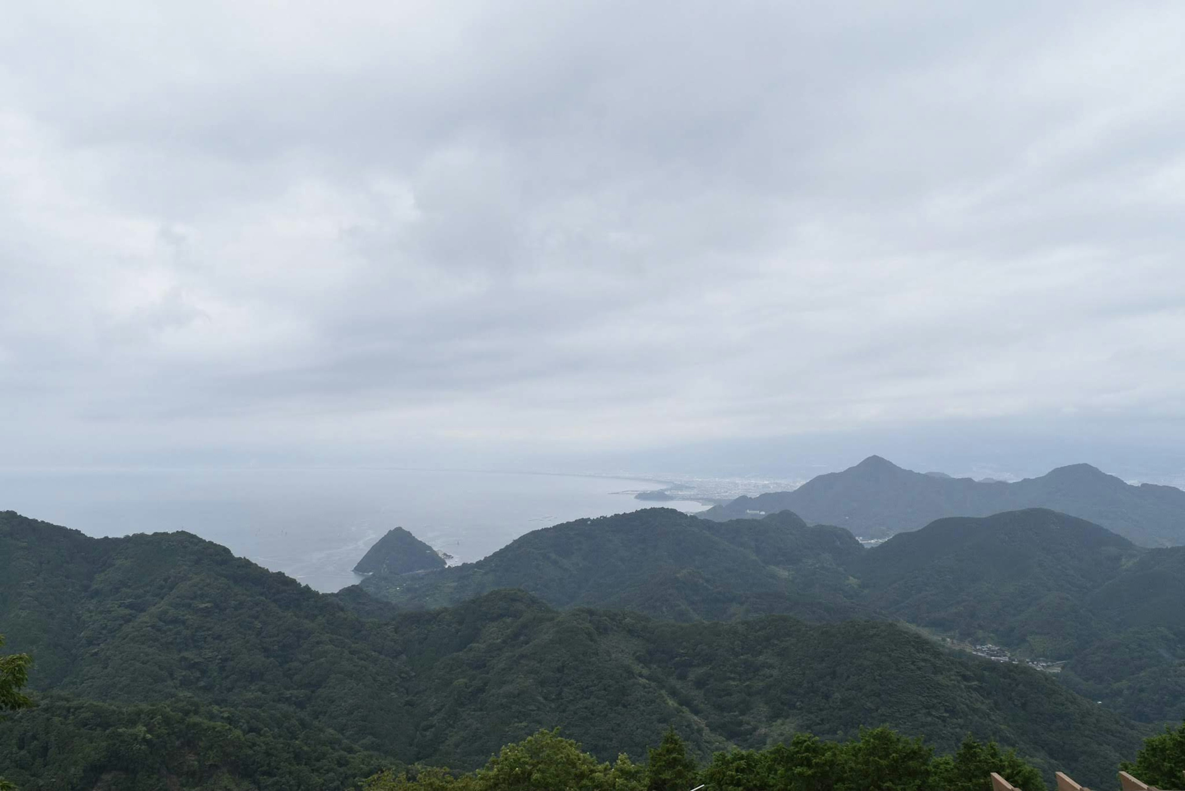 Scenic view of mountains and ocean under a cloudy sky