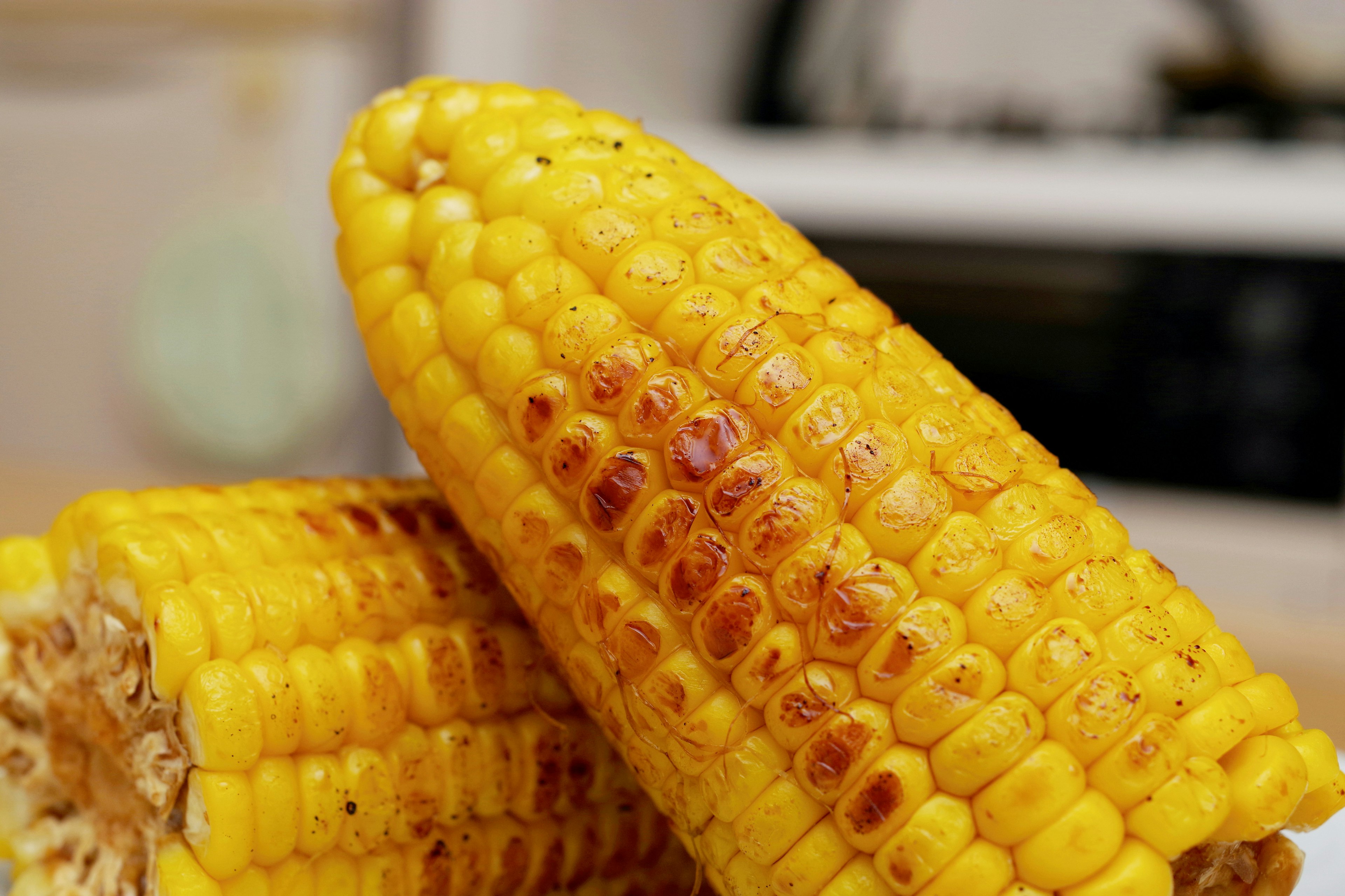 Two vibrant yellow corn cobs stacked together