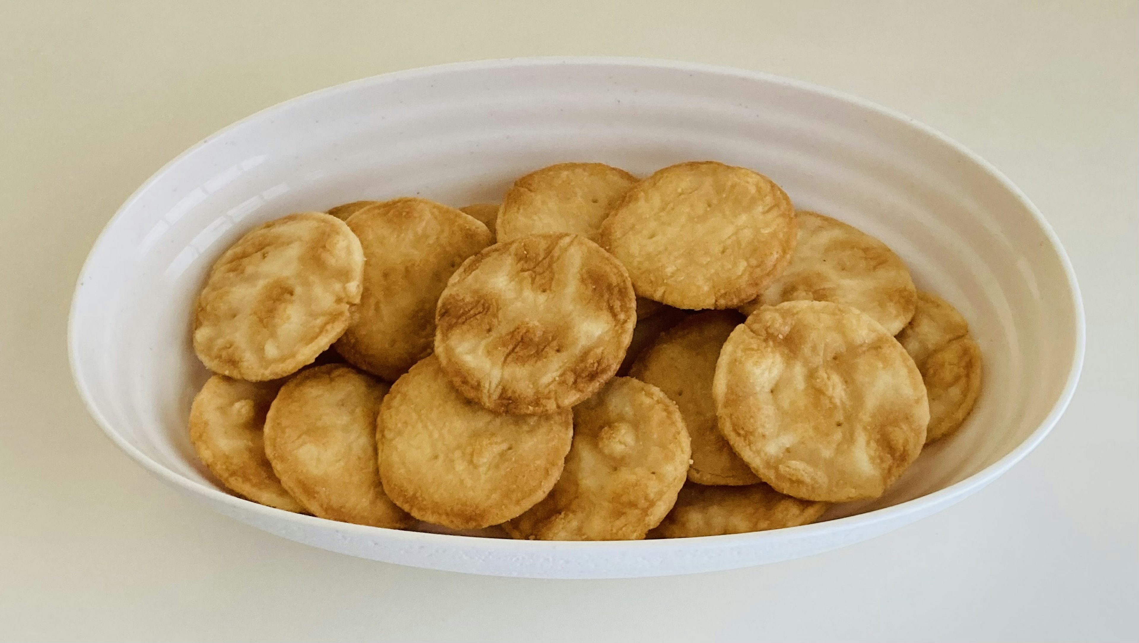 Crispy round snacks arranged in a white bowl