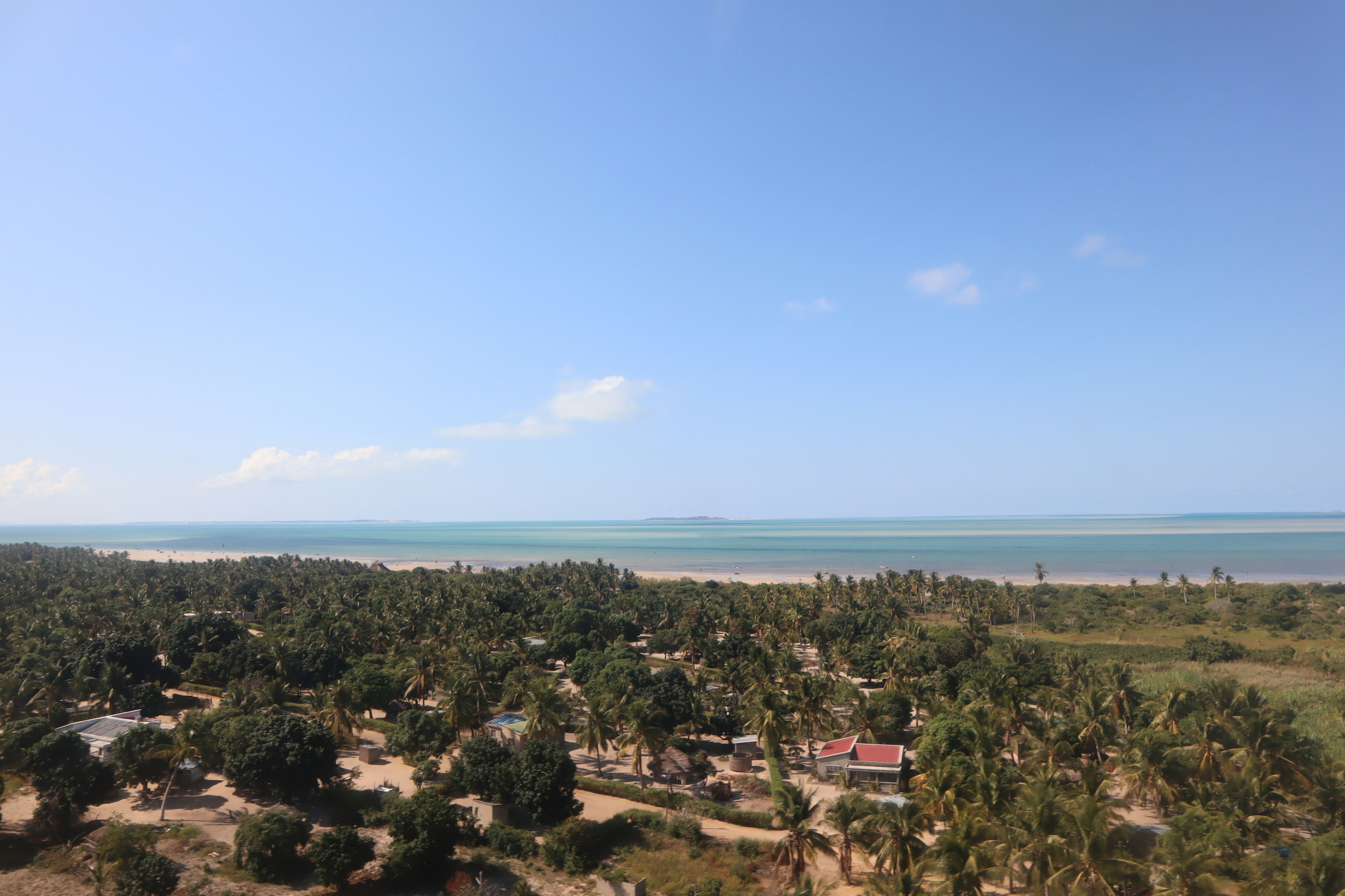 Vue pittoresque avec ciel et océan bleus verdure luxuriante et maisons éparpillées