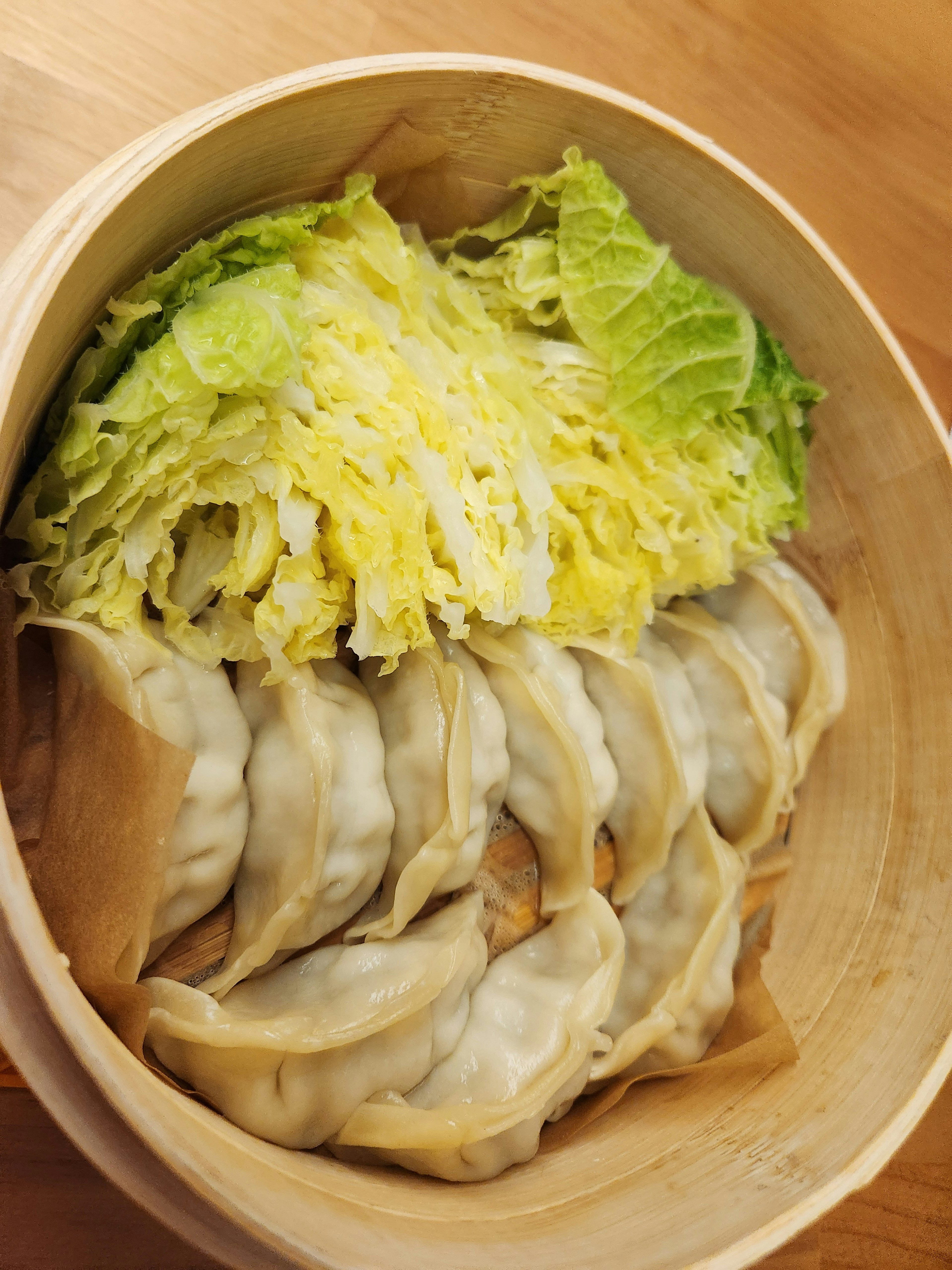 Bamboo steamer filled with dumplings and cabbage