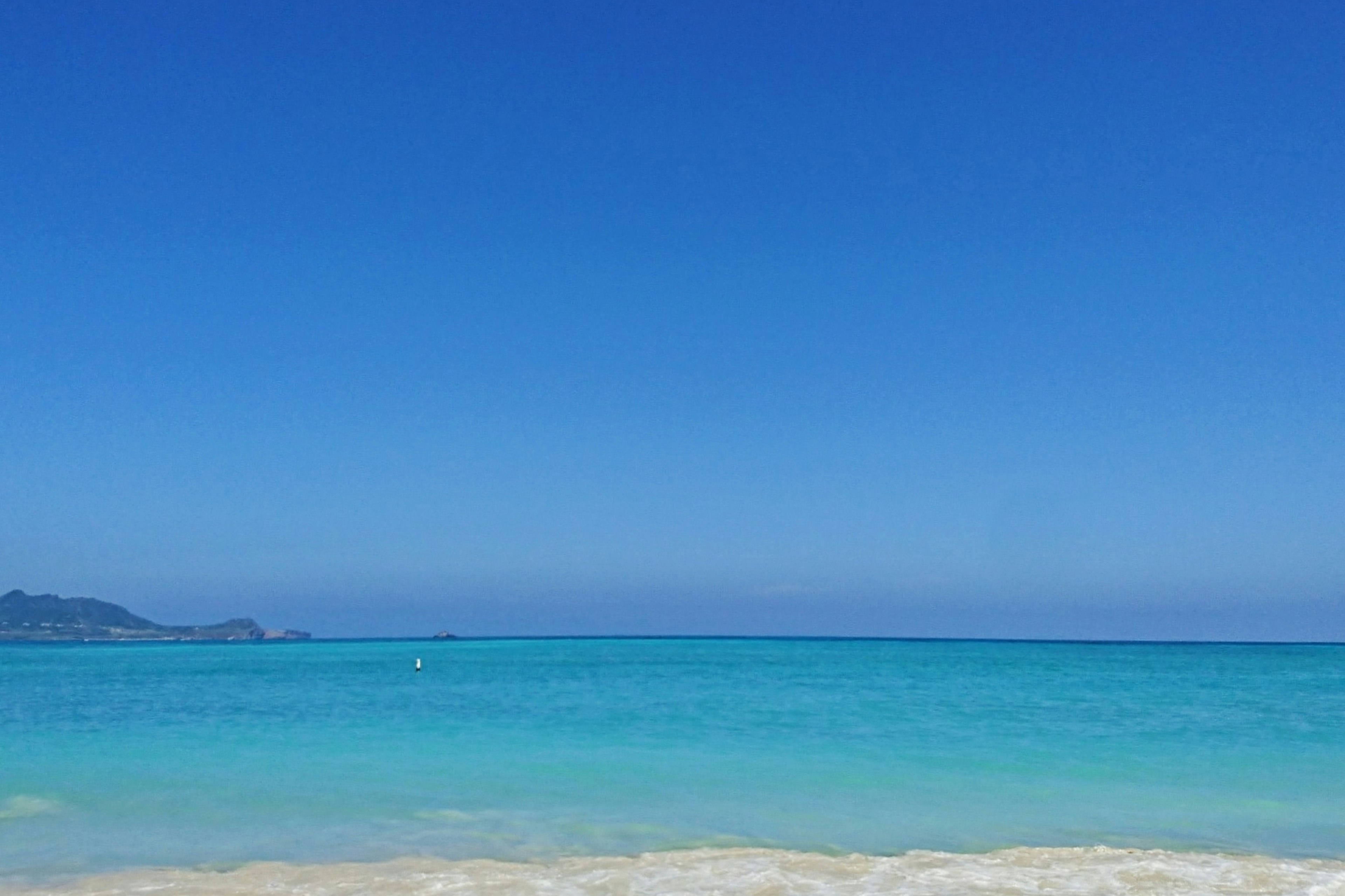 Pemandangan pantai dengan lautan biru dan langit cerah