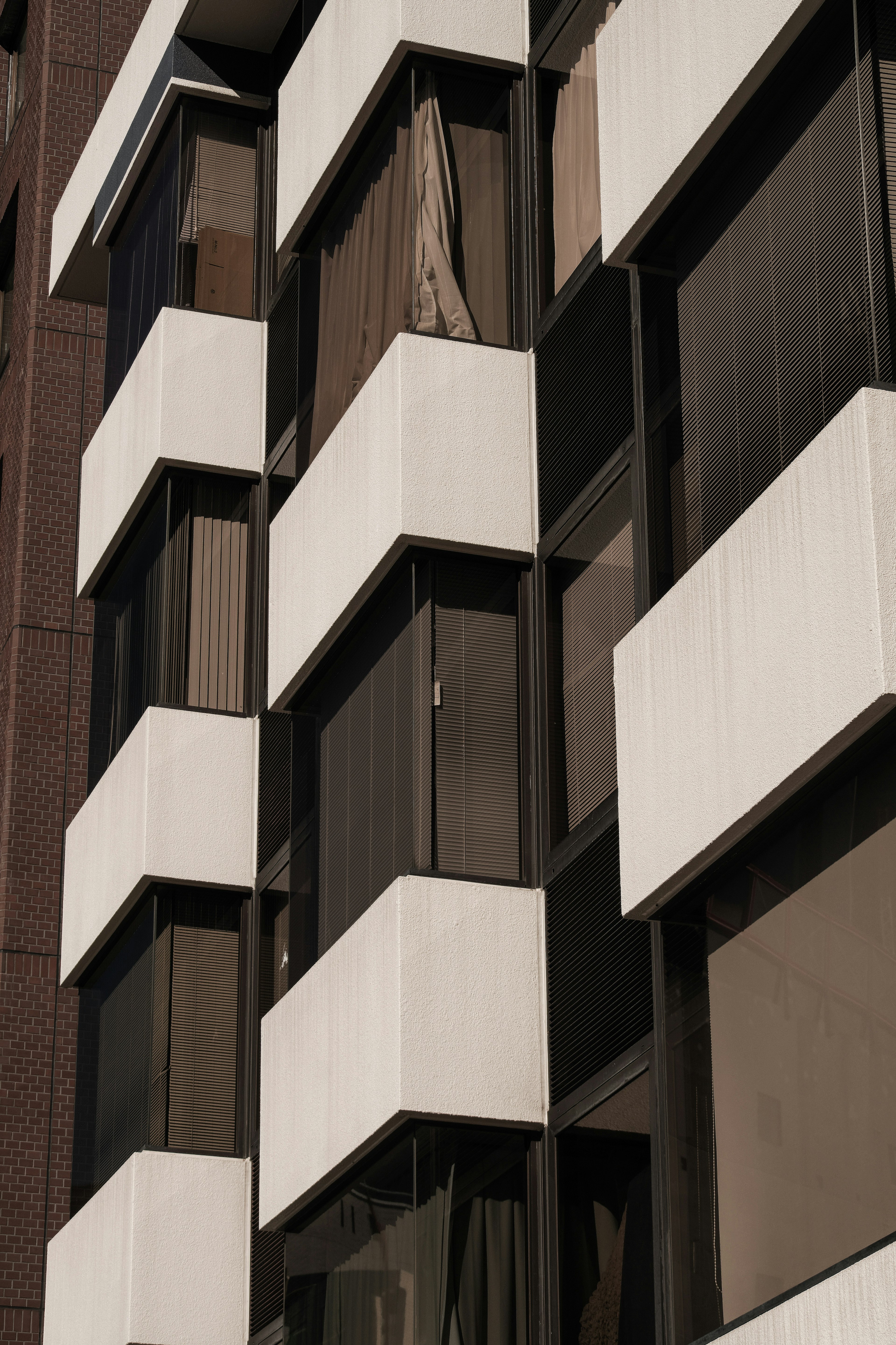 Close-up of a building facade with white and black elements featuring distinctive windows