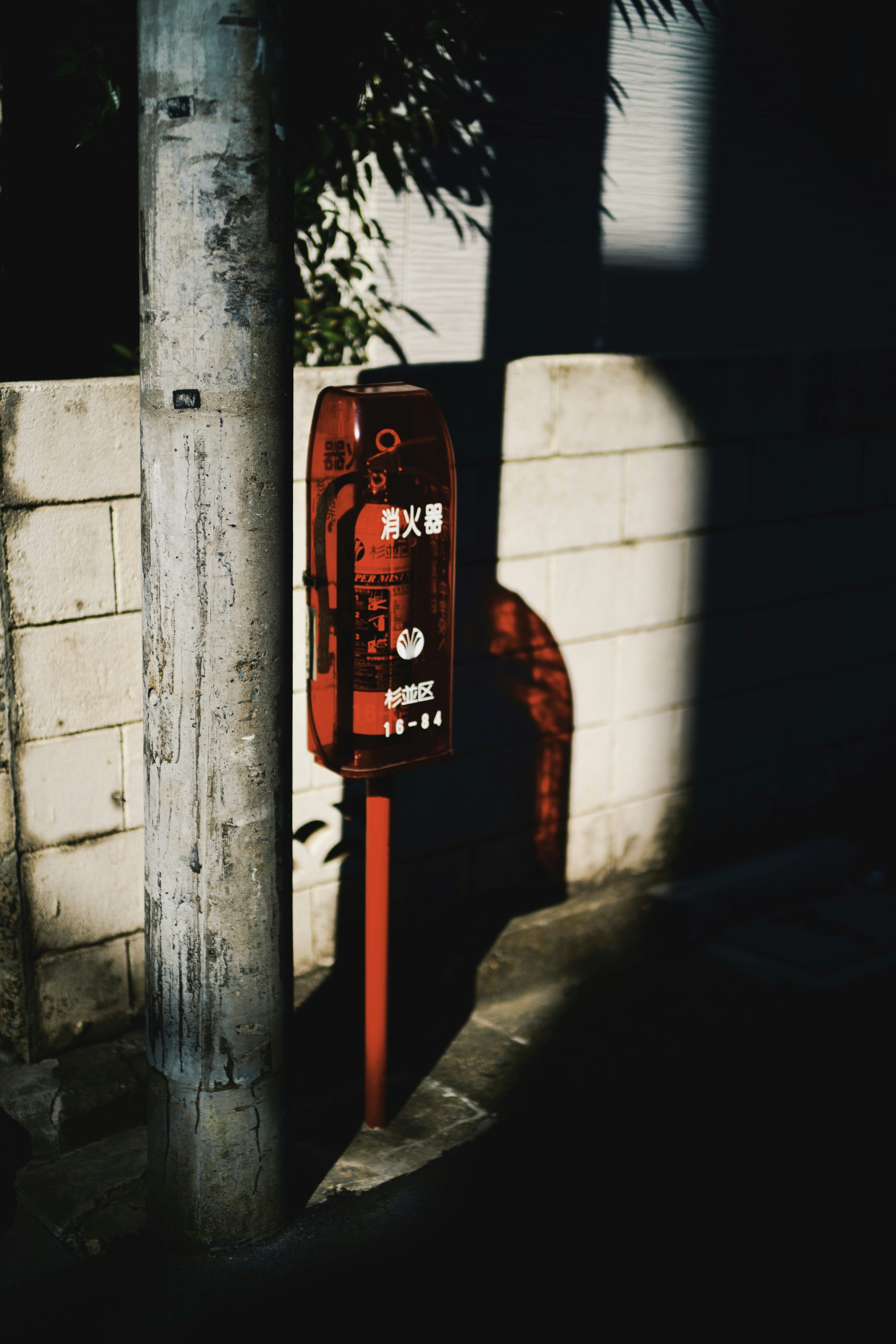 Rote Telefonzelle steht nahe einer Wand