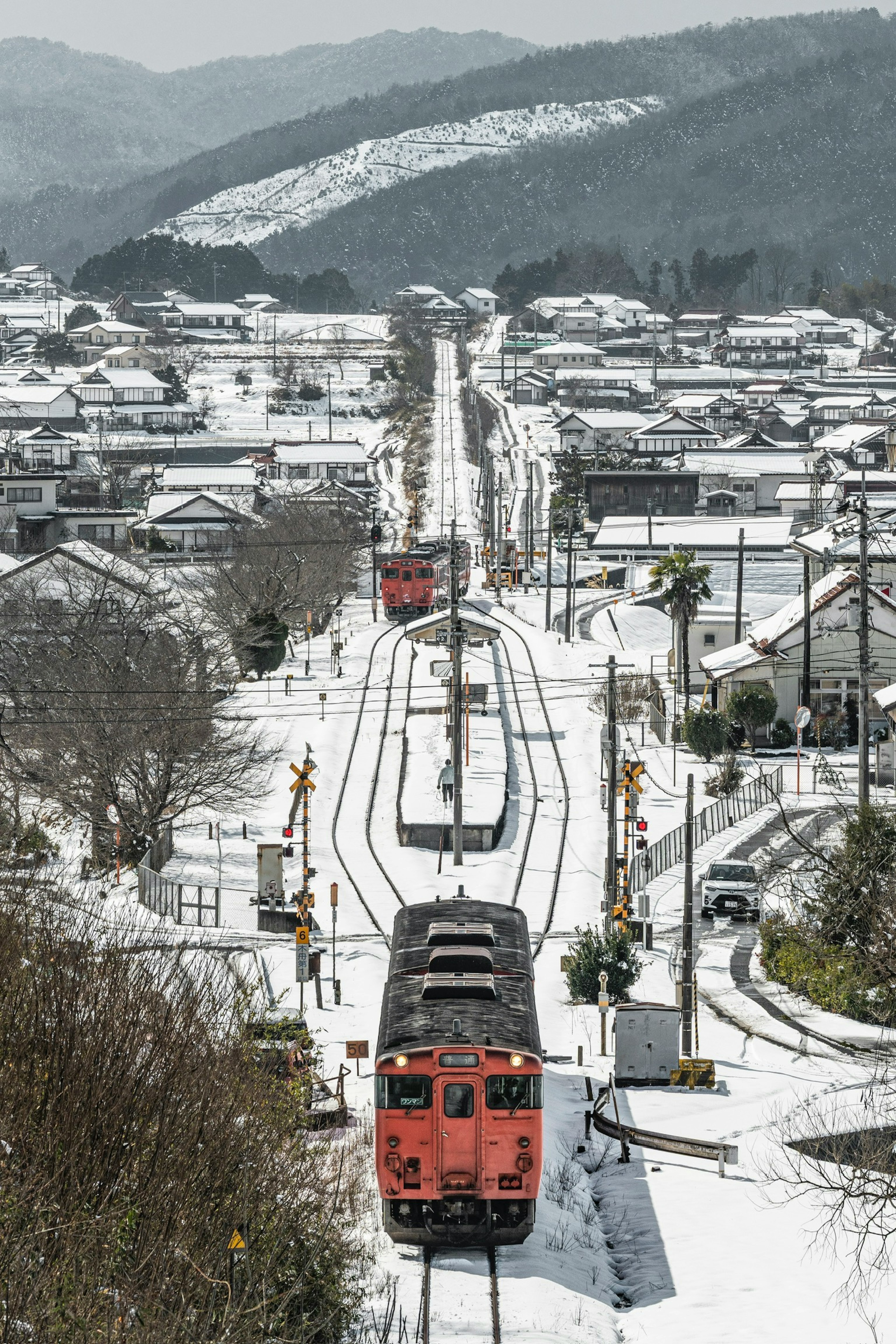 在雪地景觀中行駛的紅色火車