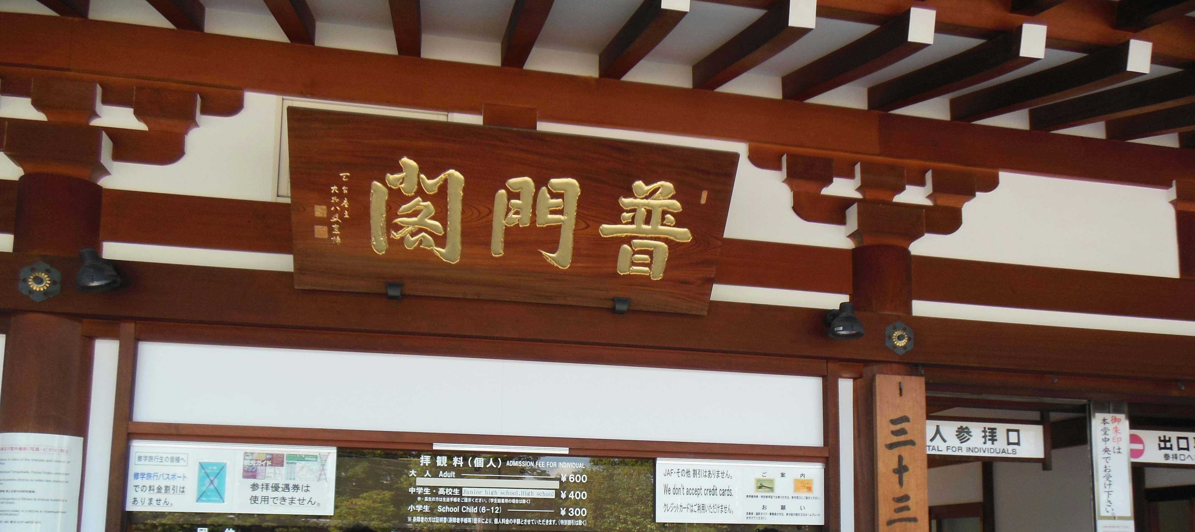 Wooden sign with golden characters displaying the shop name