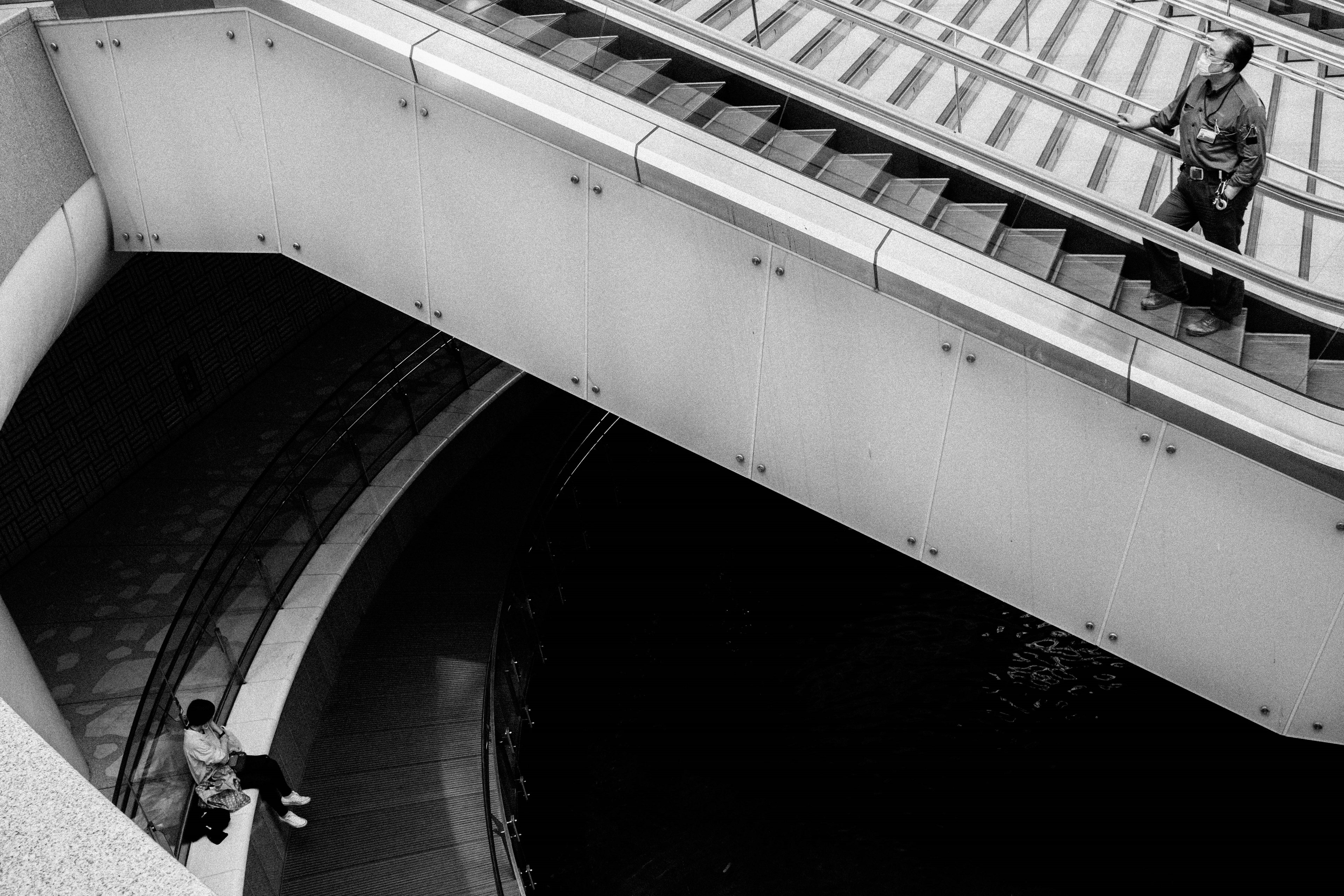 階段と曲線的な通路が交差するモノクロの都市風景