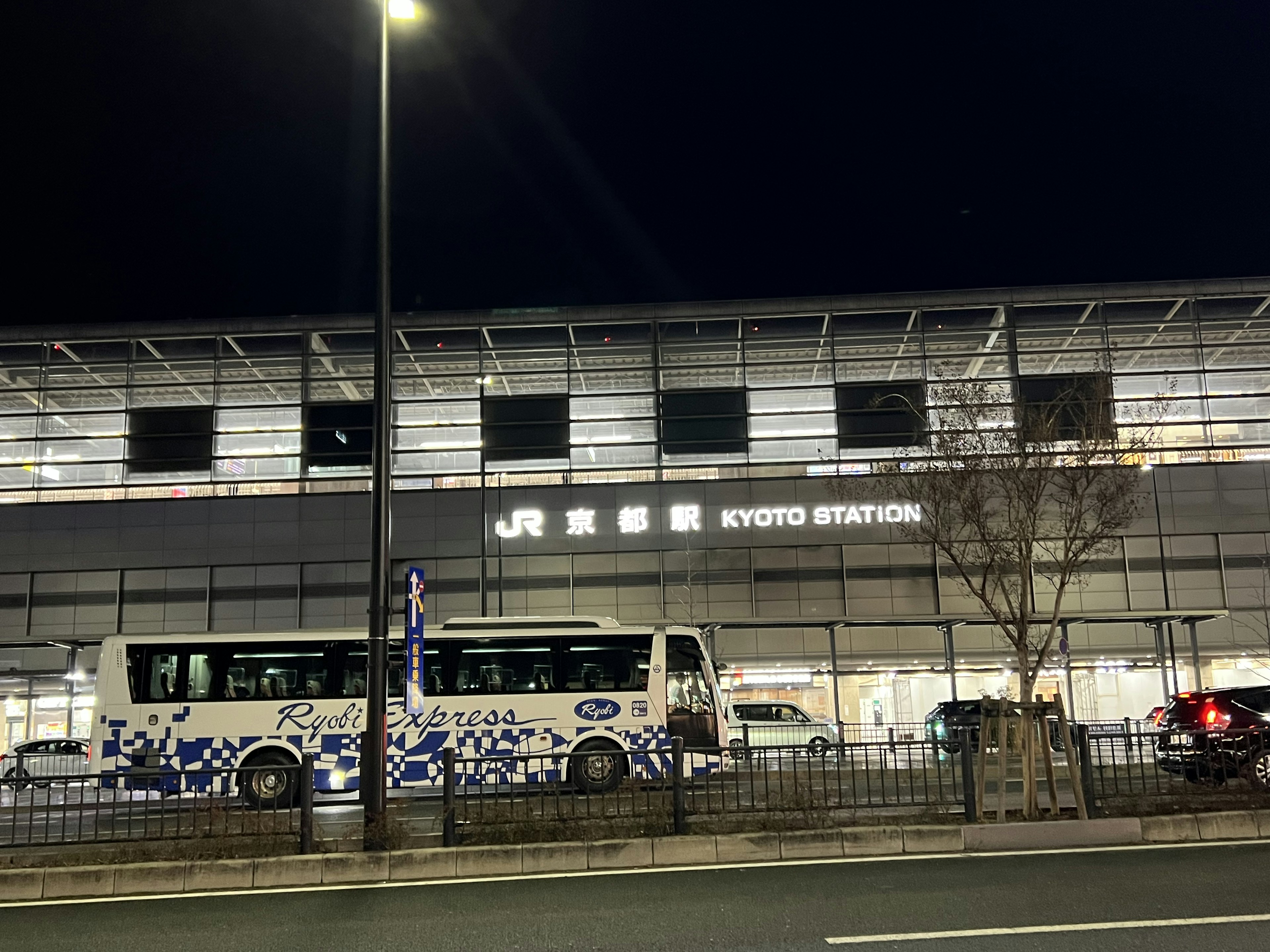 Pemandangan luar Stasiun Kyoto di malam hari dengan bus