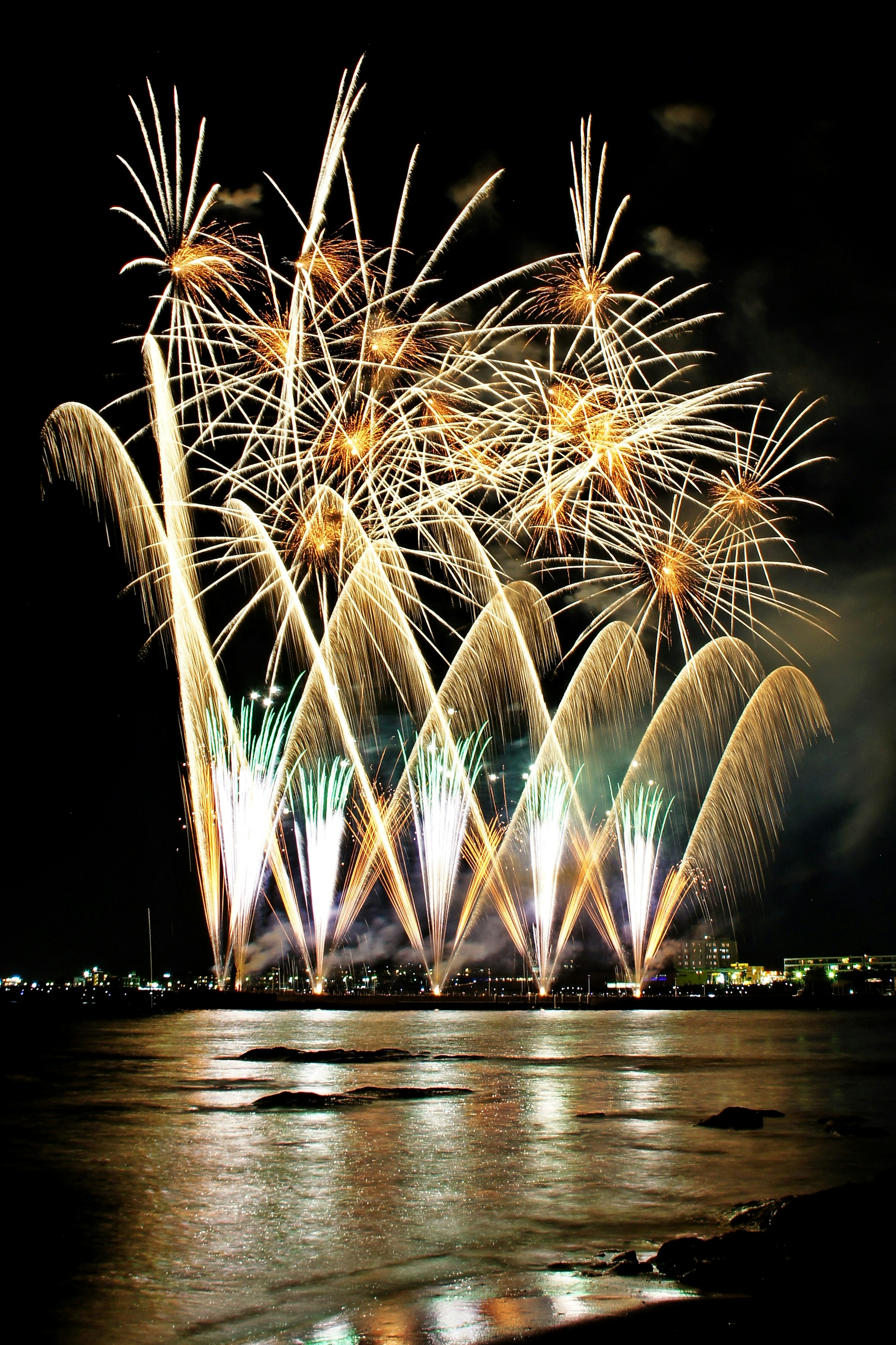 夜空に映える華やかな花火が水面に反射している