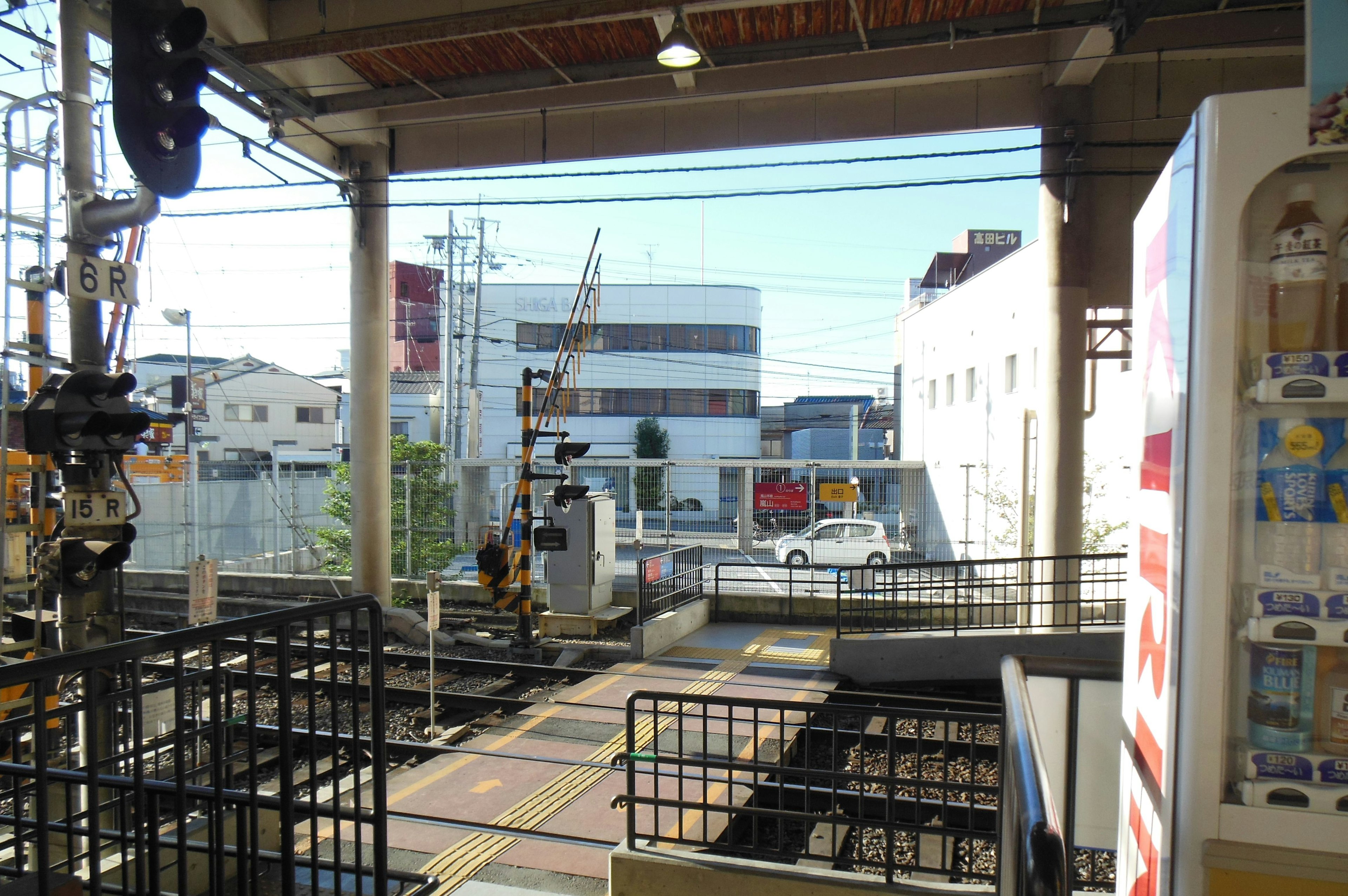 View from a train station platform featuring railway tracks and buildings