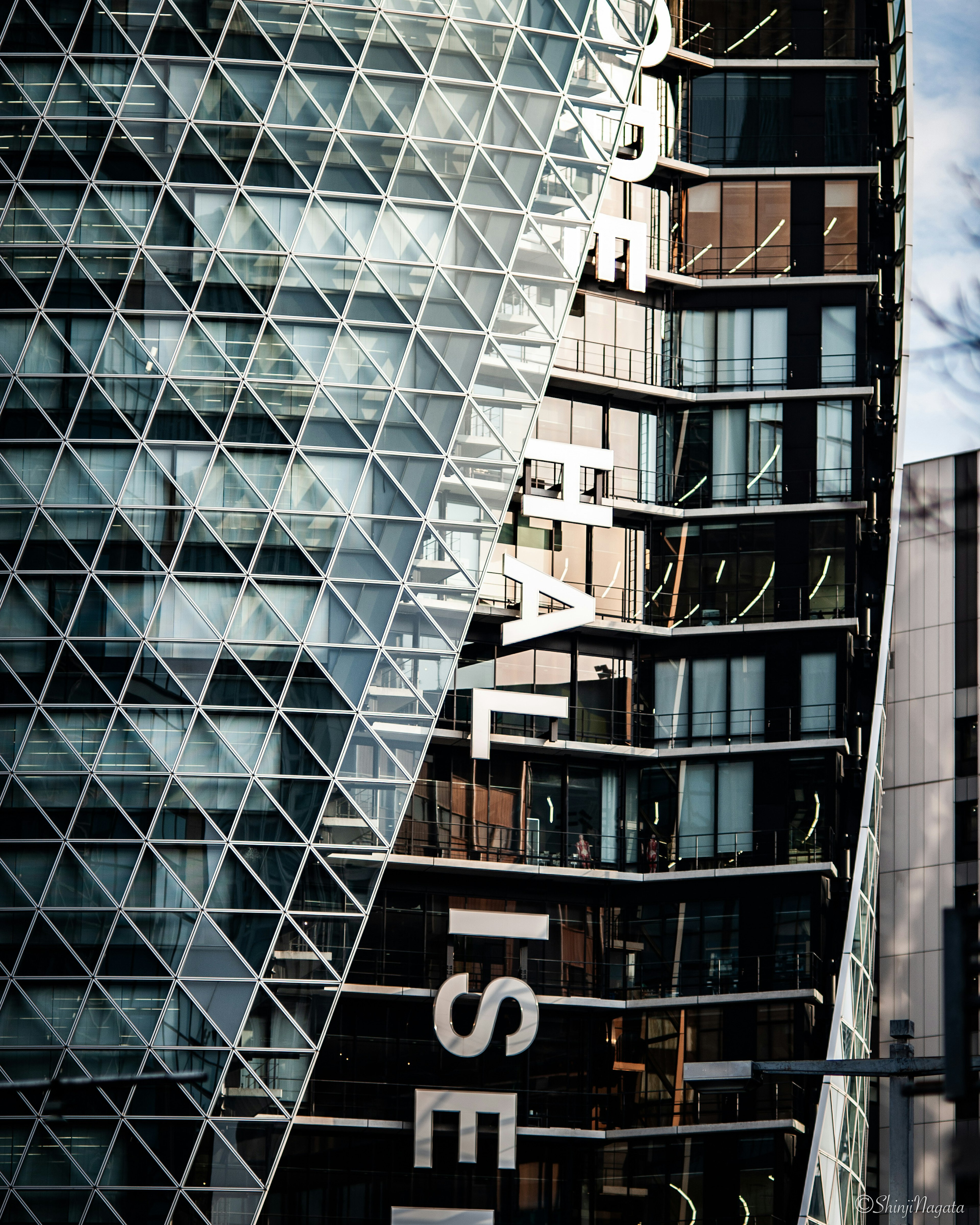 Modern building facade featuring a distinctive angled glass and metal structure