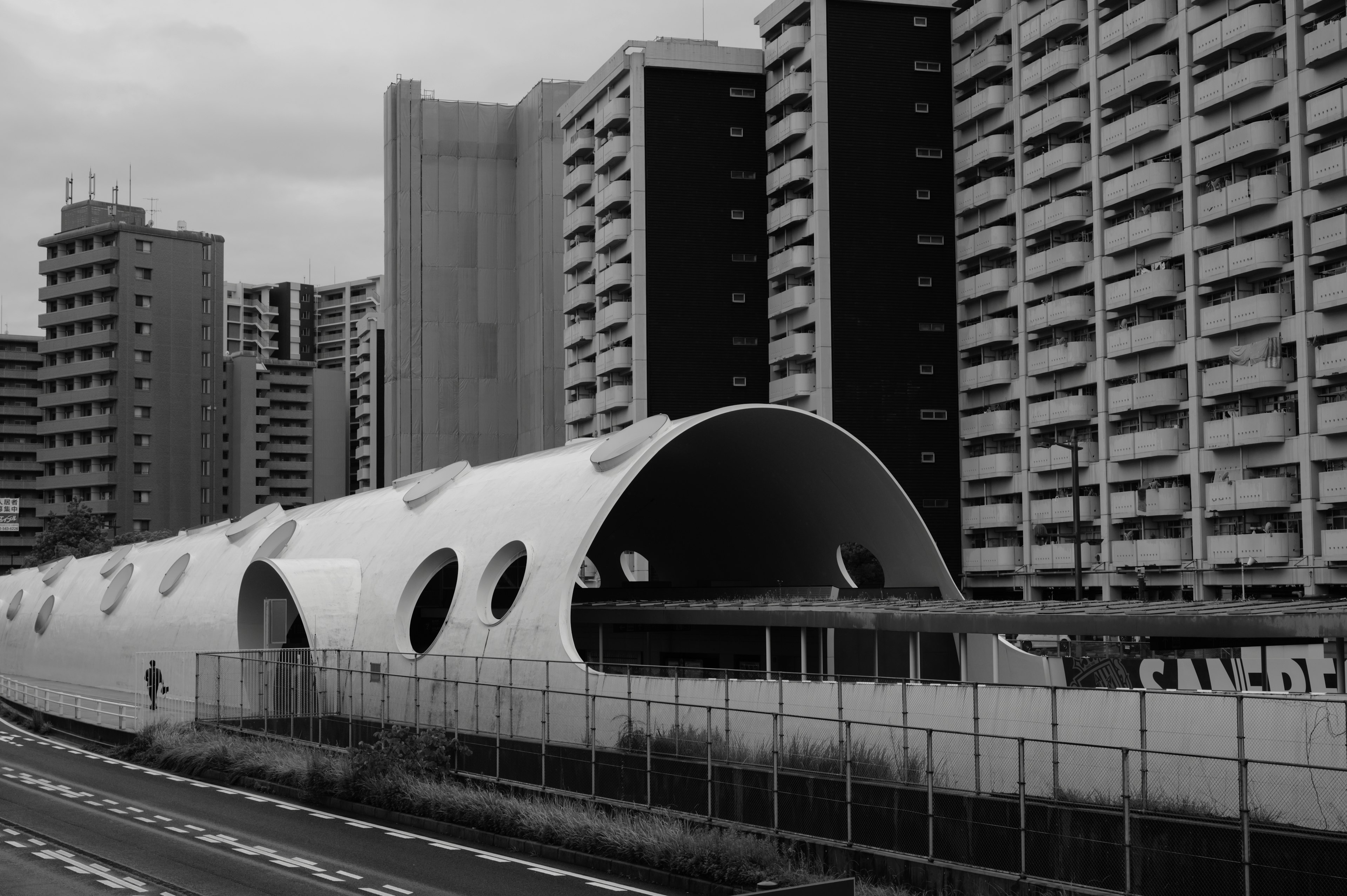 Modern architecture featuring a tunnel structure in a black and white urban landscape