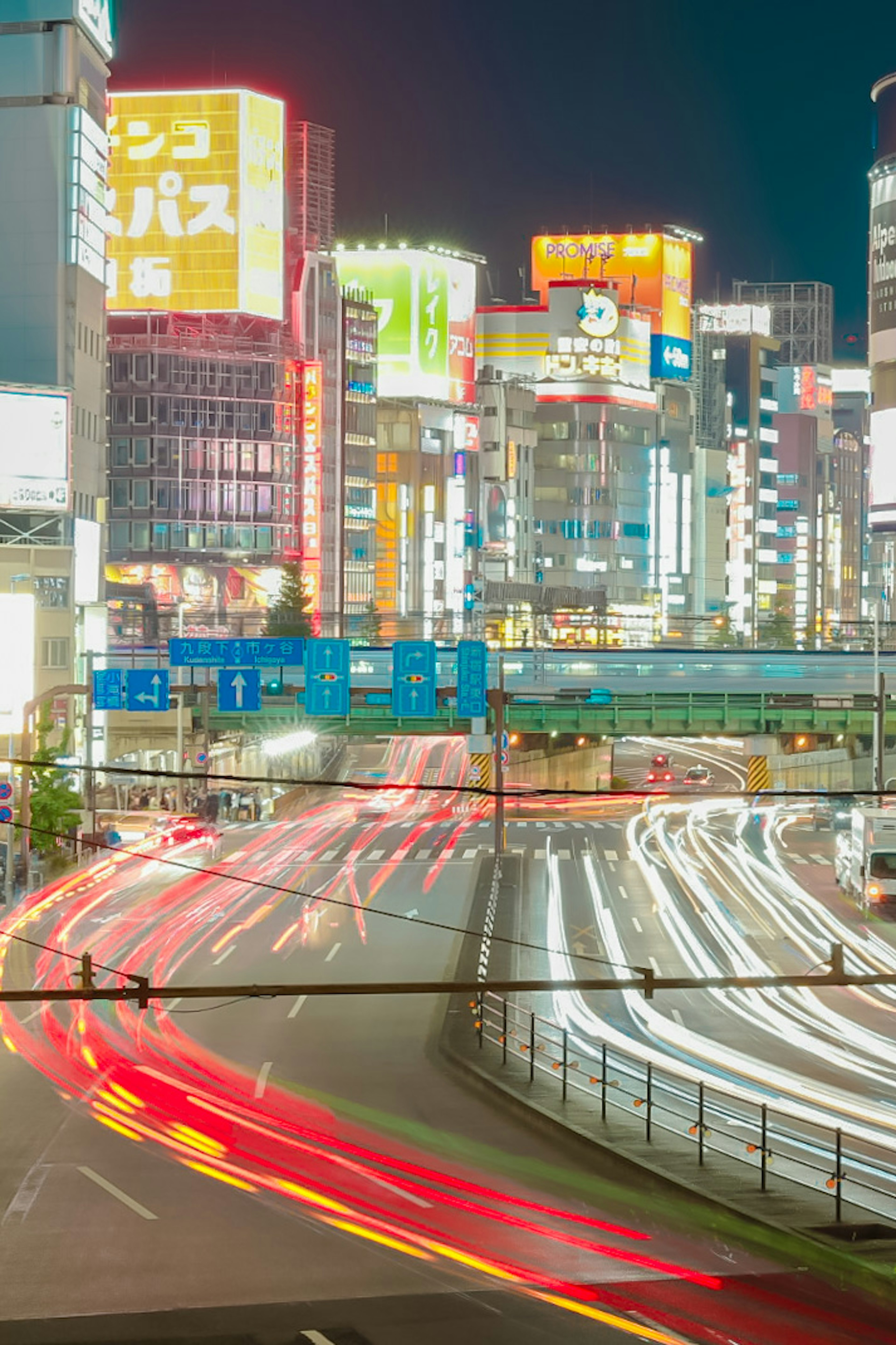 Vista nocturna del paisaje urbano de Tokio con luces de coches en movimiento