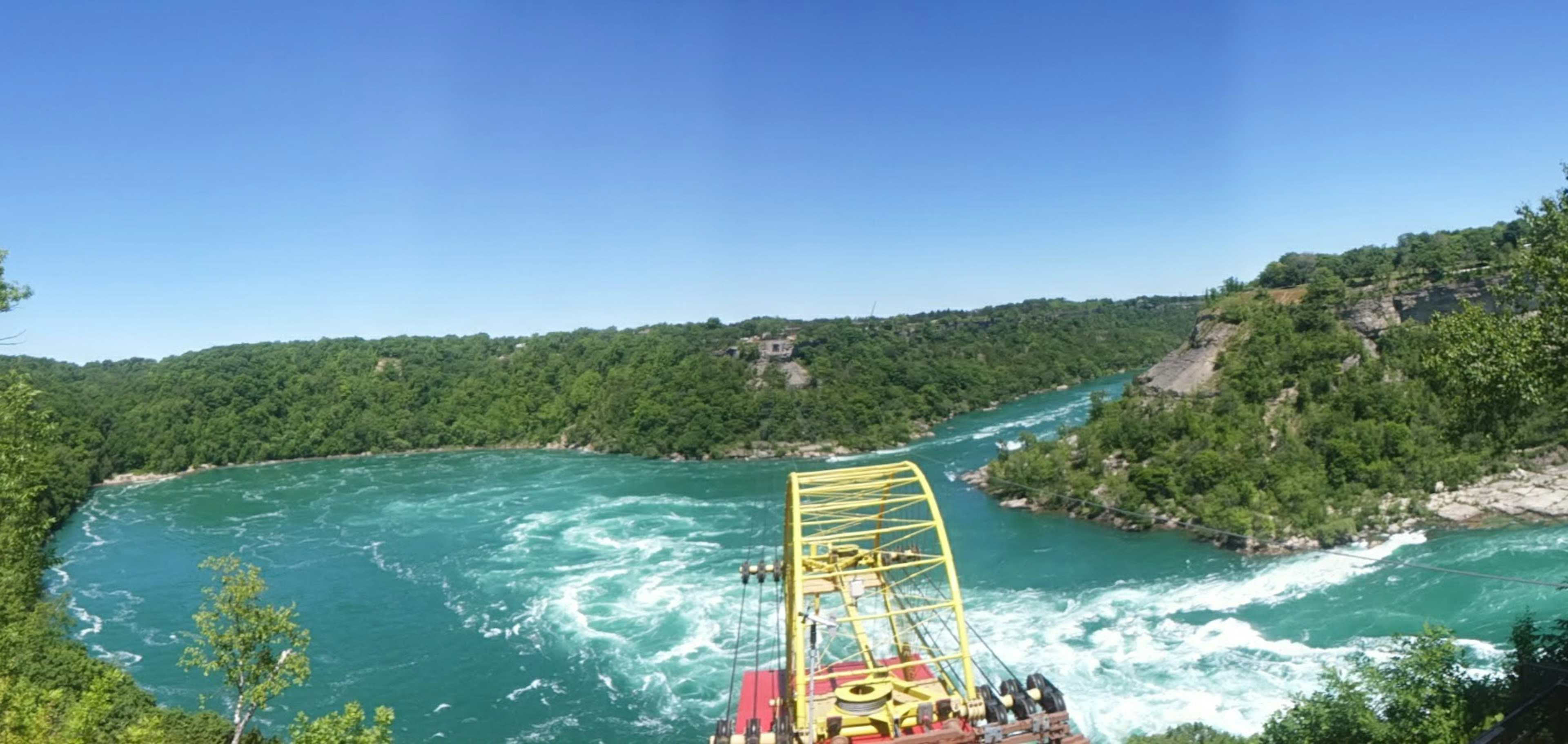 Pemandangan panorama sungai biru dikelilingi oleh pepohonan hijau subur