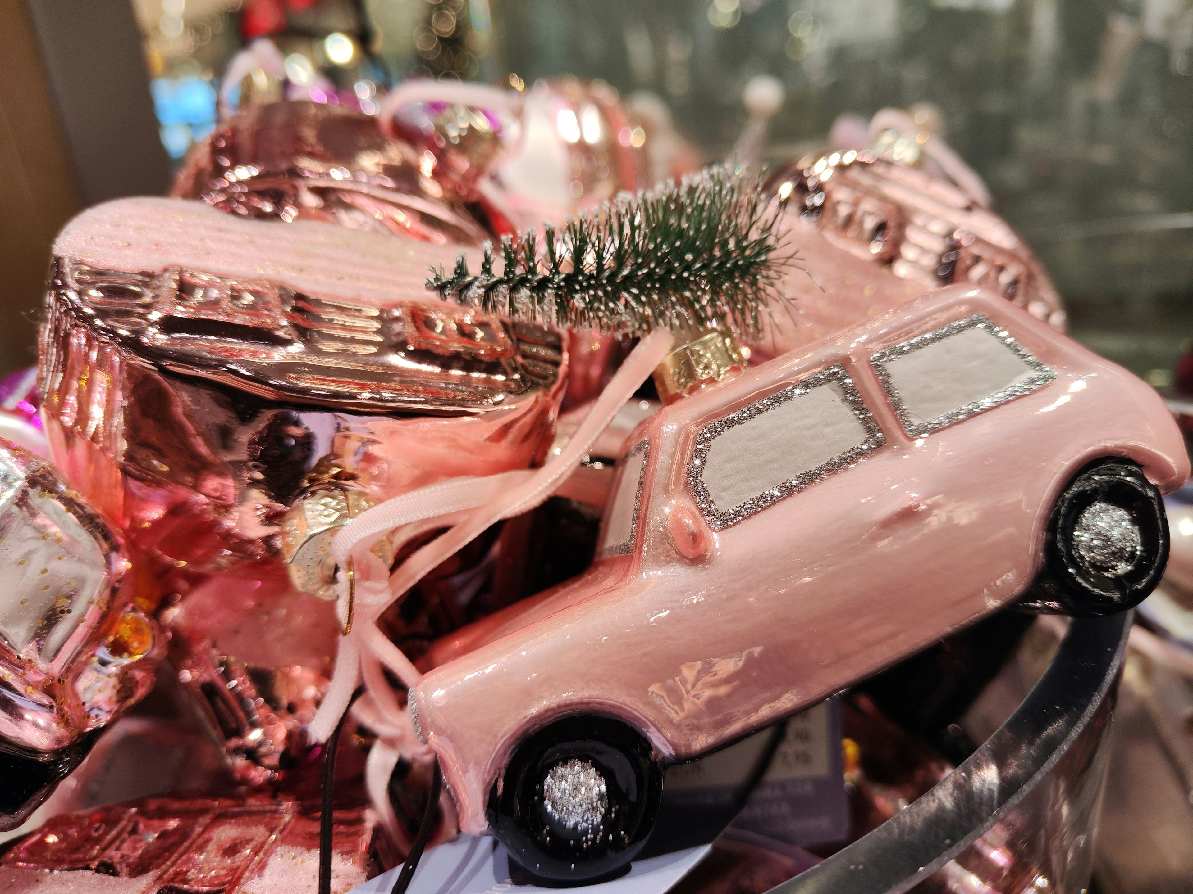 Mobil mini berwarna pink dihiasi dengan pohon Natal kecil