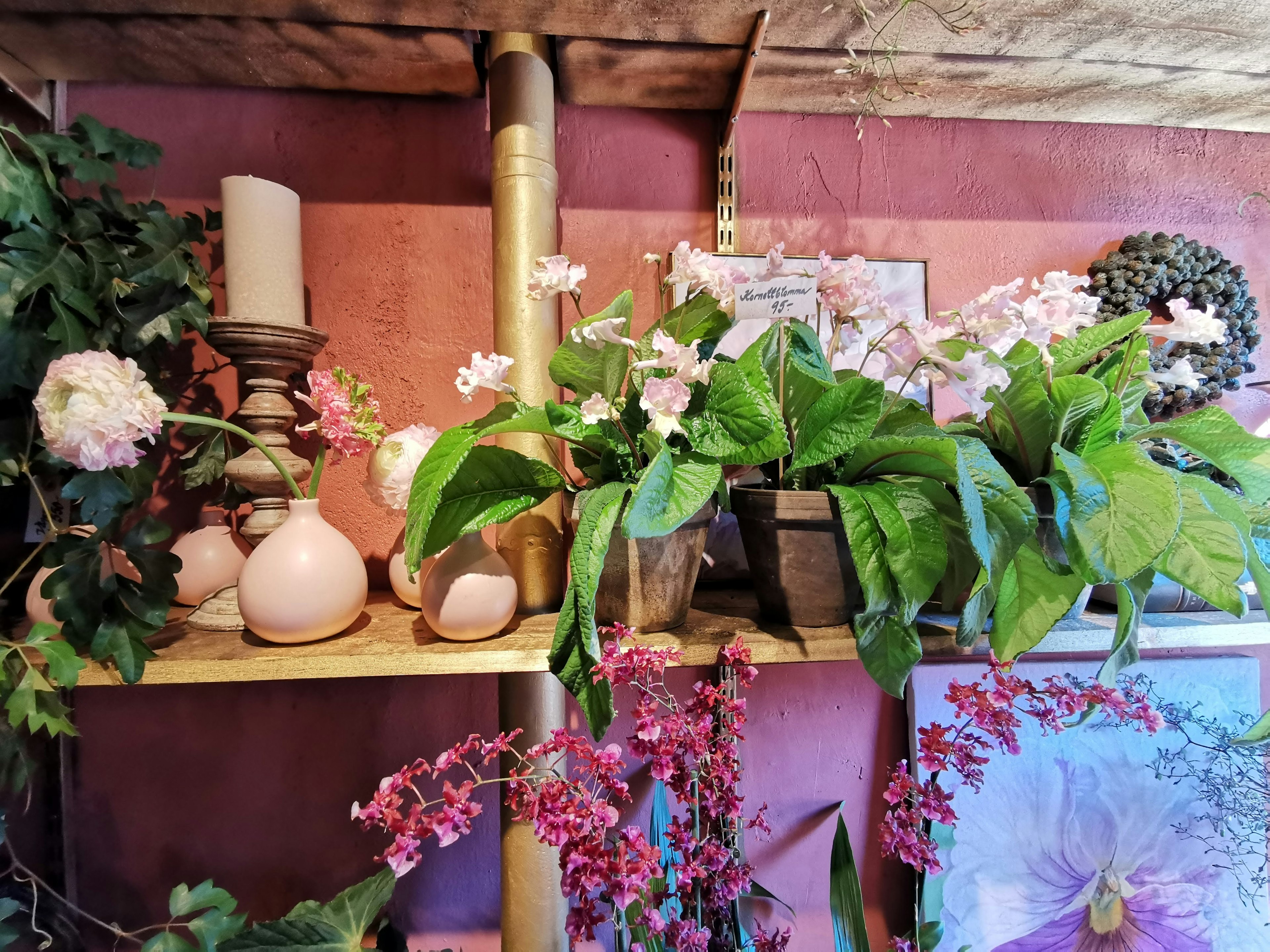 Una hermosa escena con flores y decoraciones de velas en una estantería