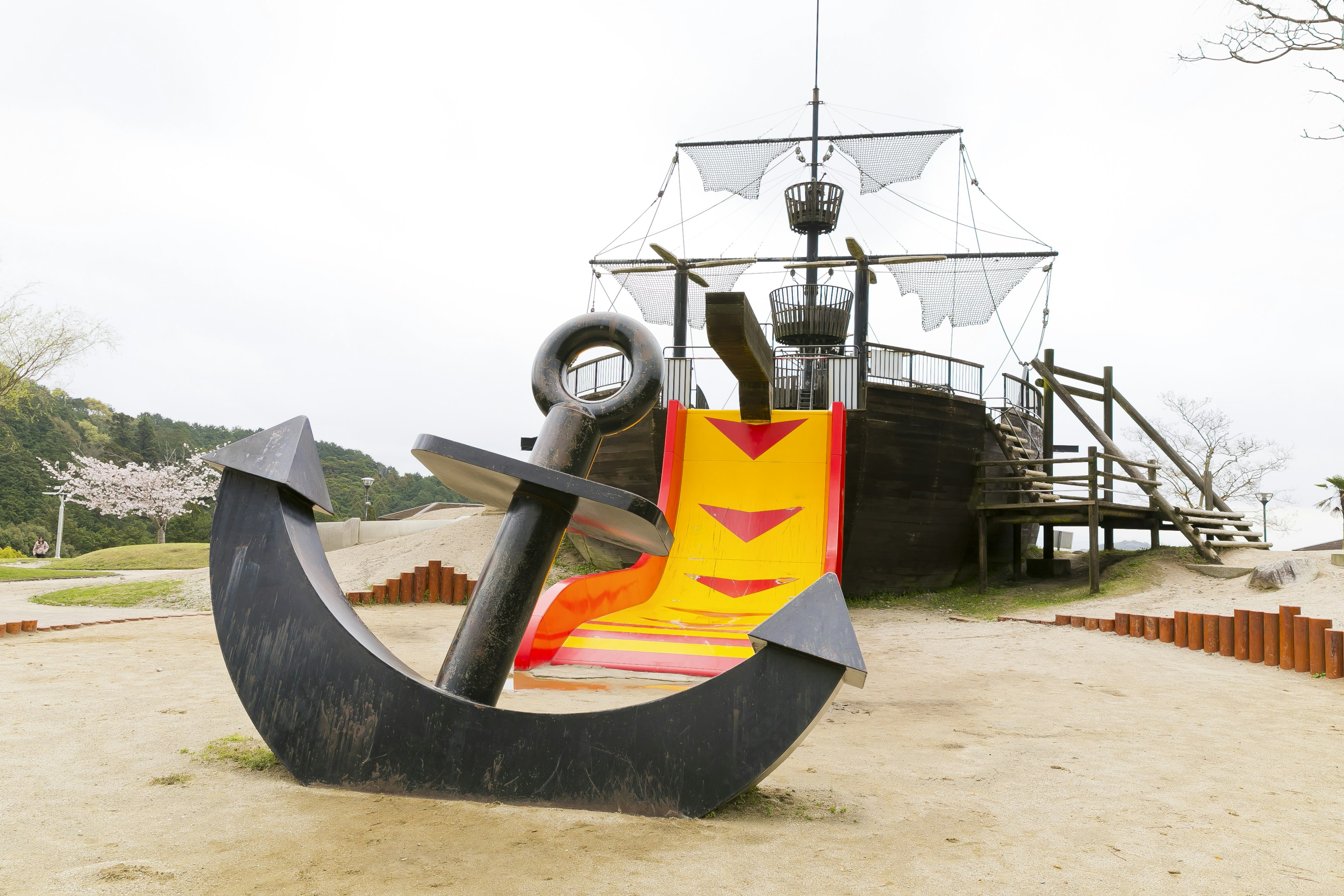 Aire de jeux avec un toboggan en forme de bateau et une grande ancre