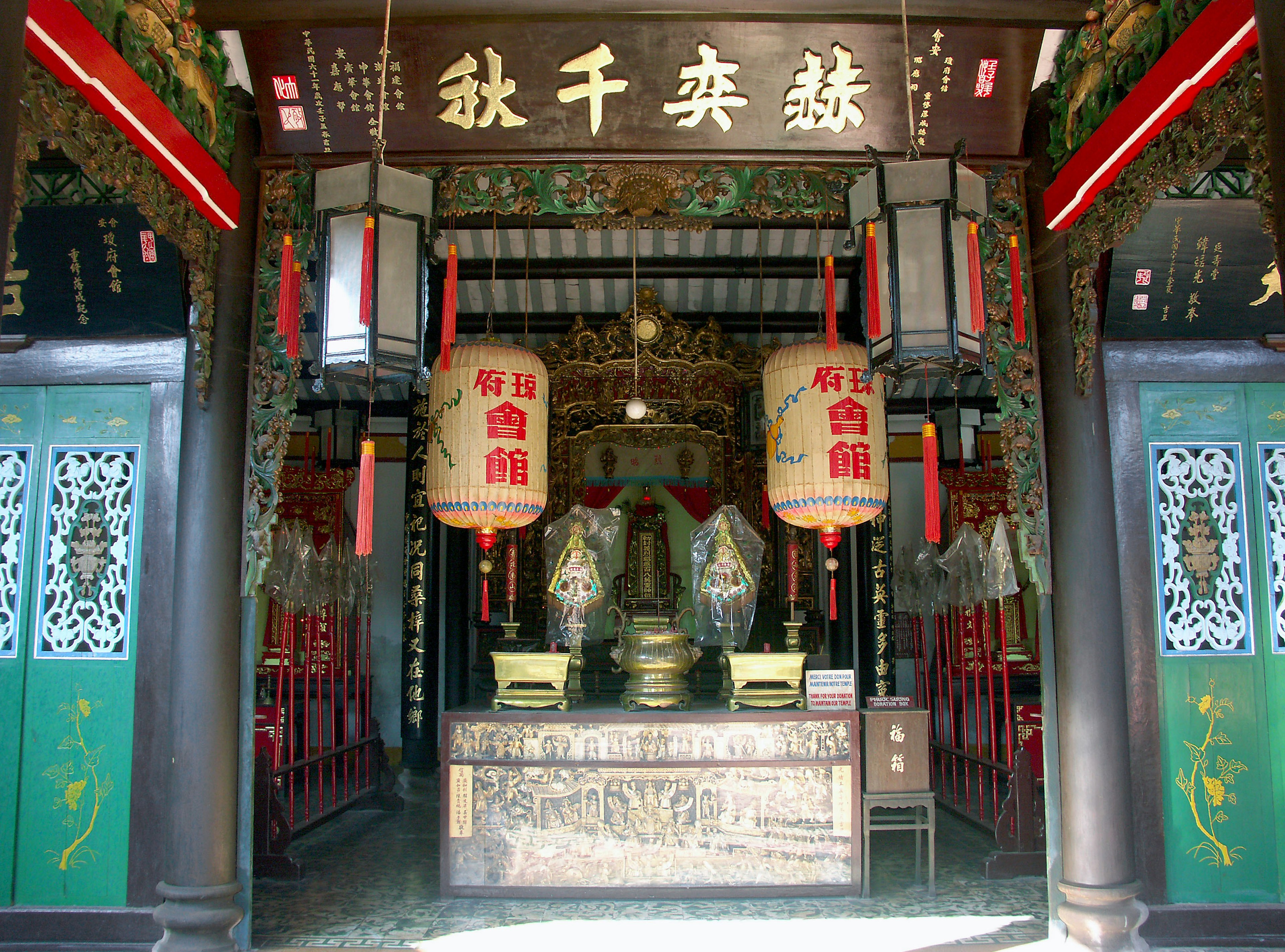 Entrada de un templo chino tradicional con un altar y faroles