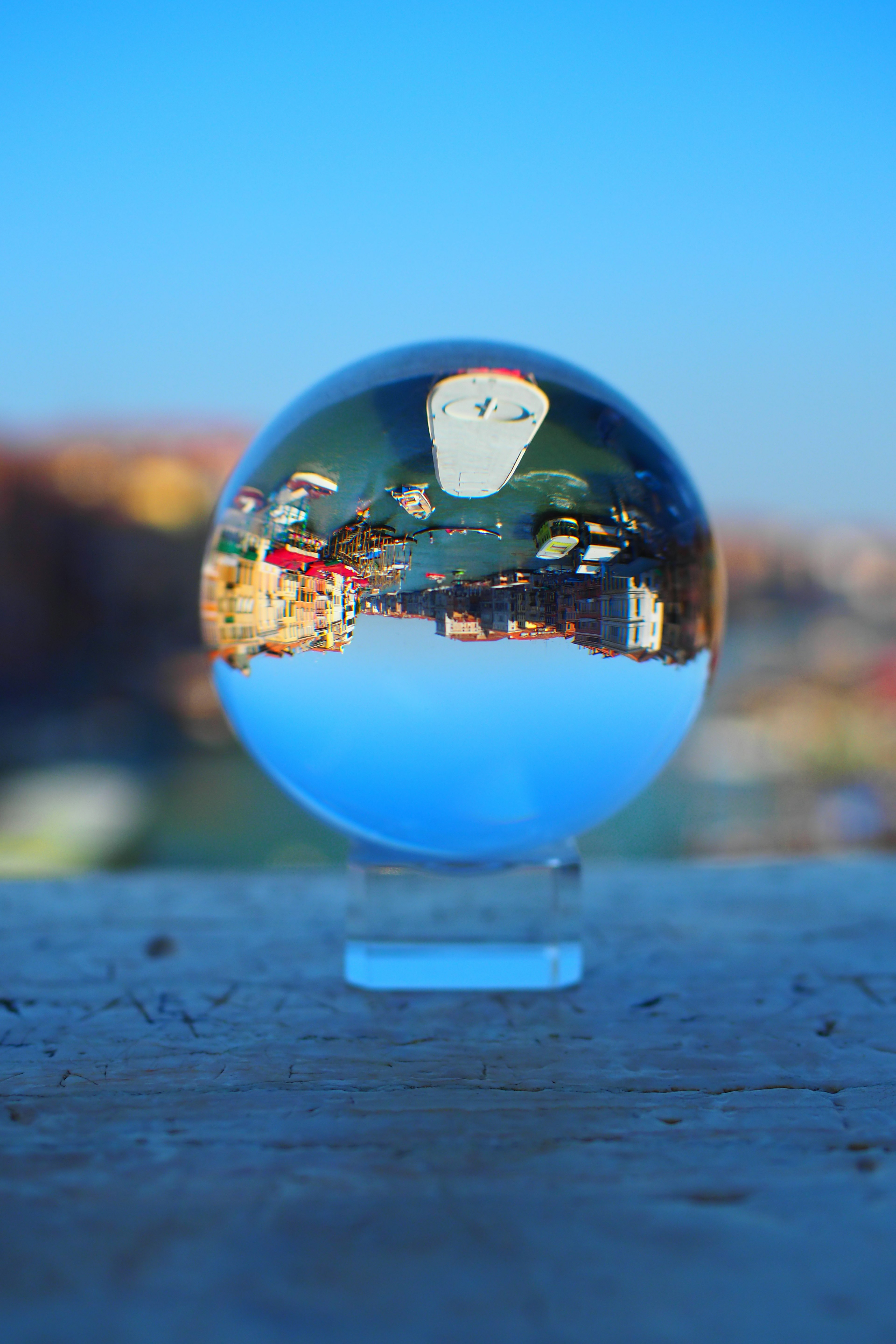 A transparent crystal ball sitting against a blue sky