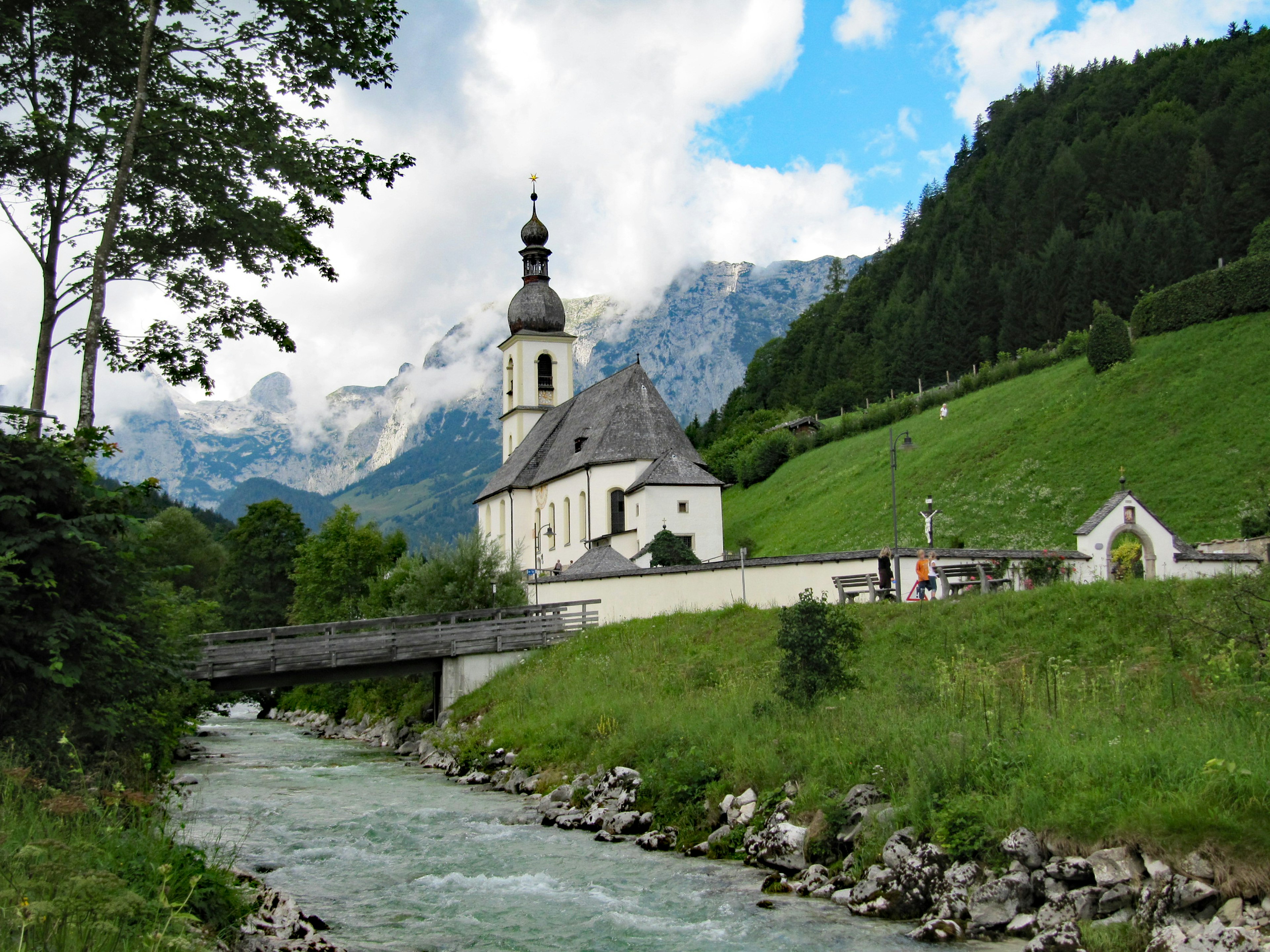 Malersicher Blick auf eine Kirche an einem Fluss umgeben von Bergen