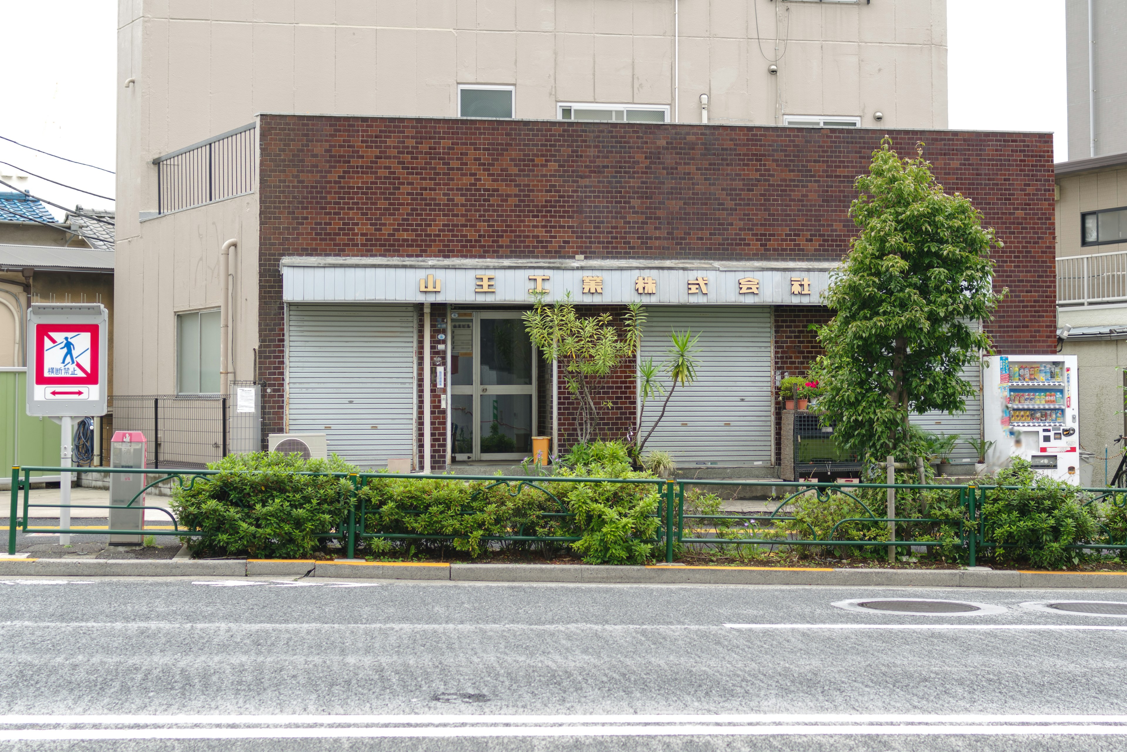 Exterior of a building with a brown facade and green landscaping