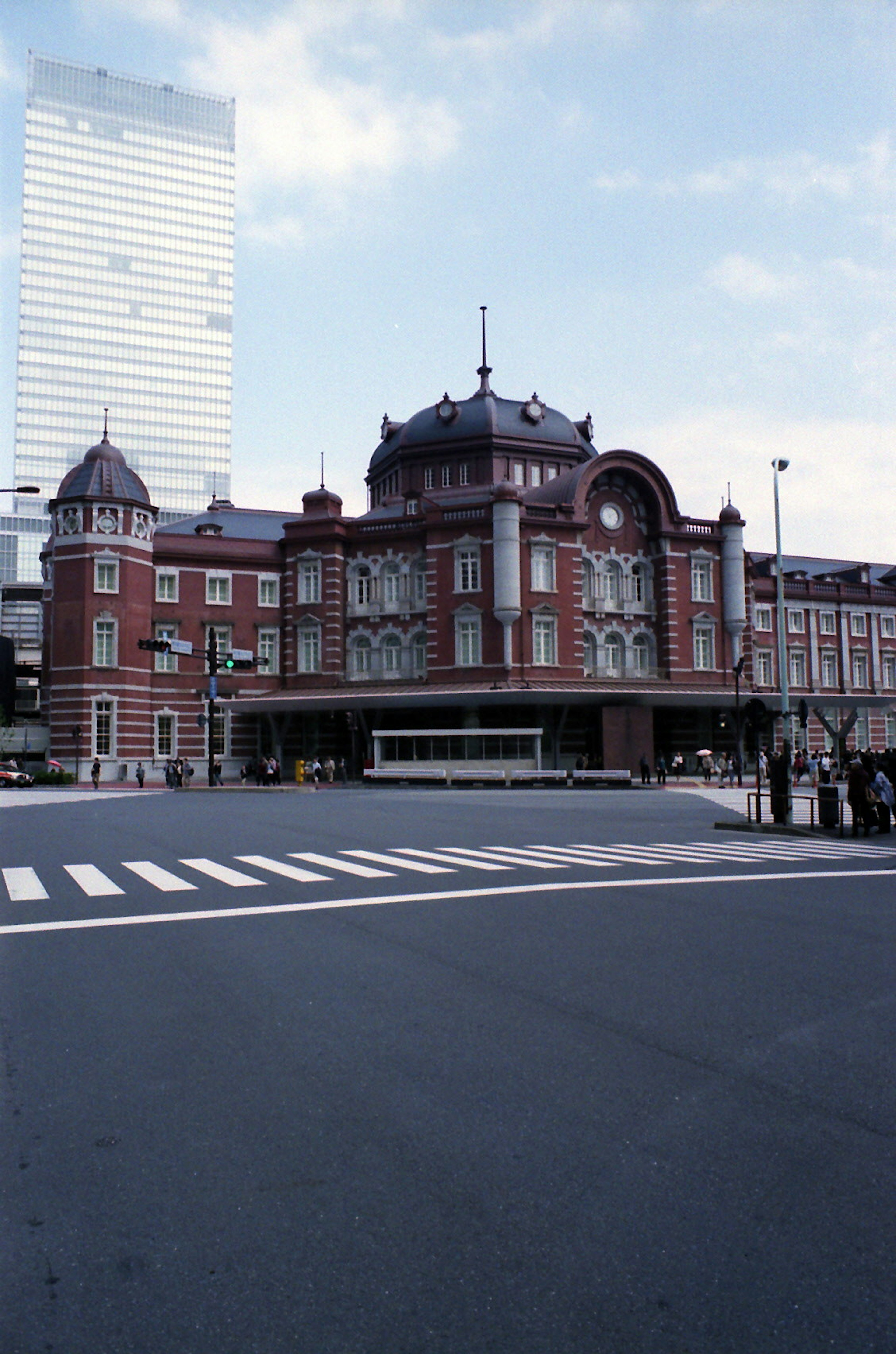 東京駅の美しい赤レンガ建築と近代的な高層ビルが対比している