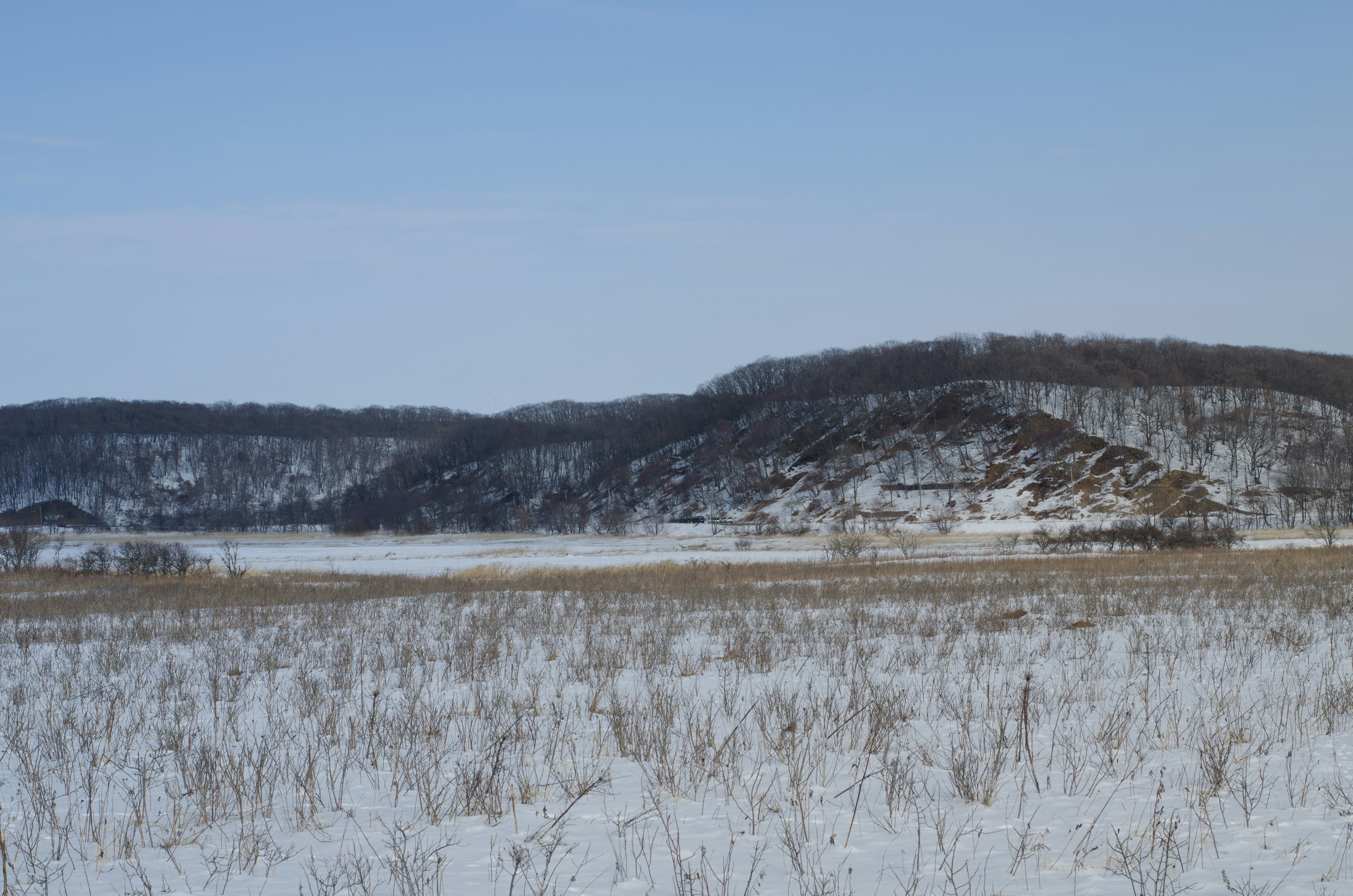 Snow-covered plain with hills in the background