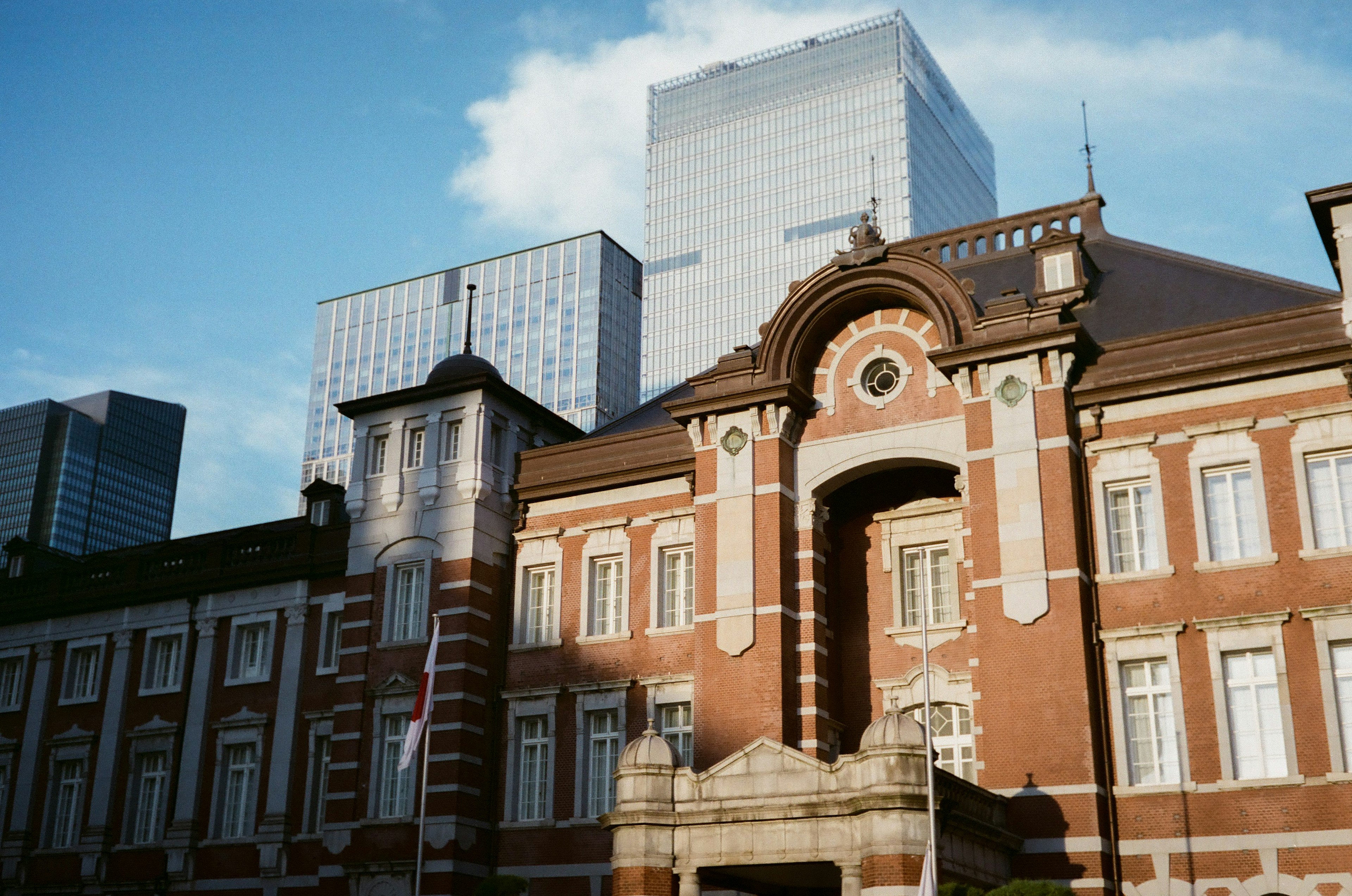 Historisches Gebäude des Bahnhofs Tokio im Kontrast zu modernen Wolkenkratzern