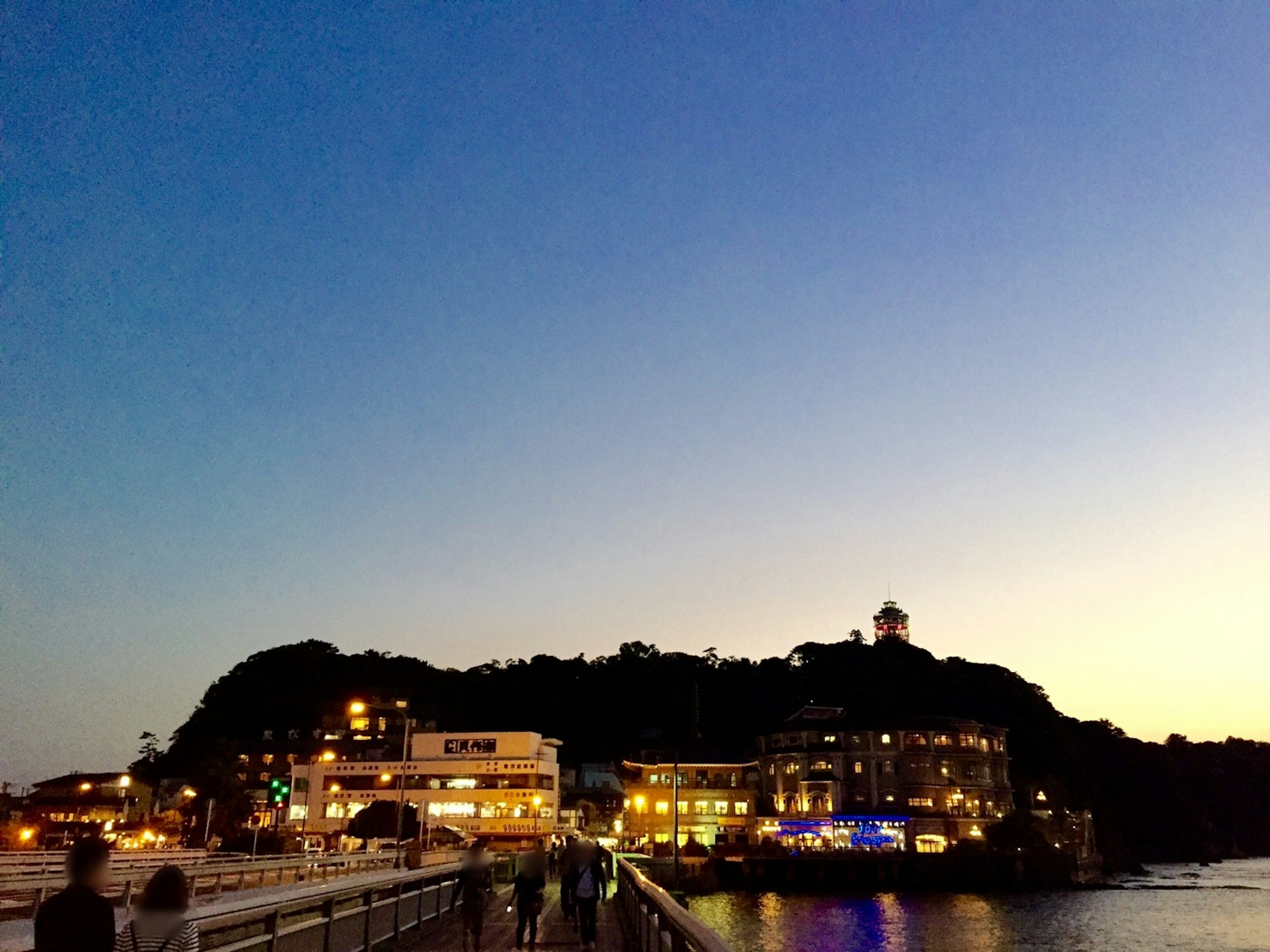 夕暮れの海岸に沿った街の風景と灯り