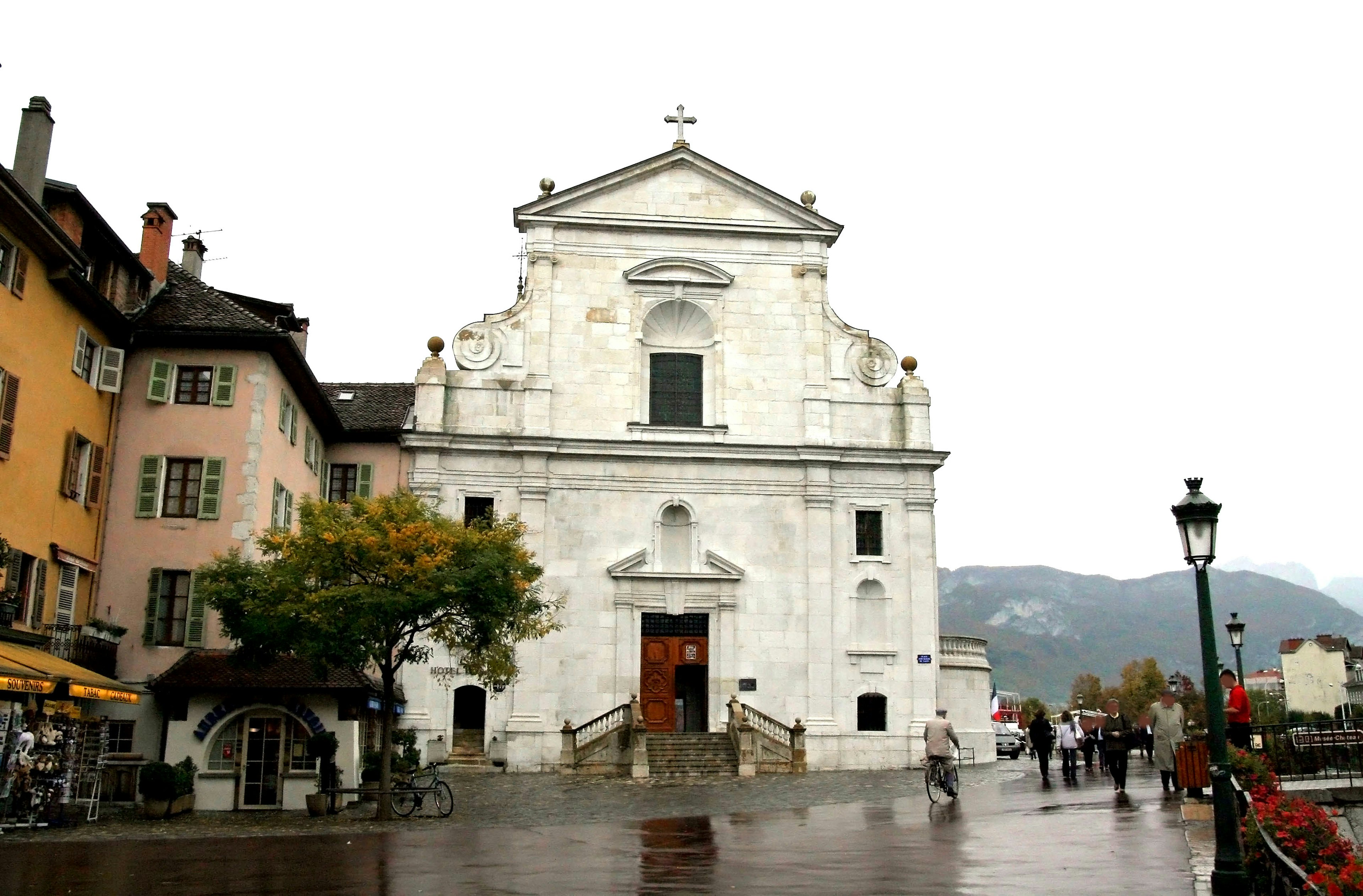 Église blanche avec des bâtiments environnants dans un cadre pluvieux