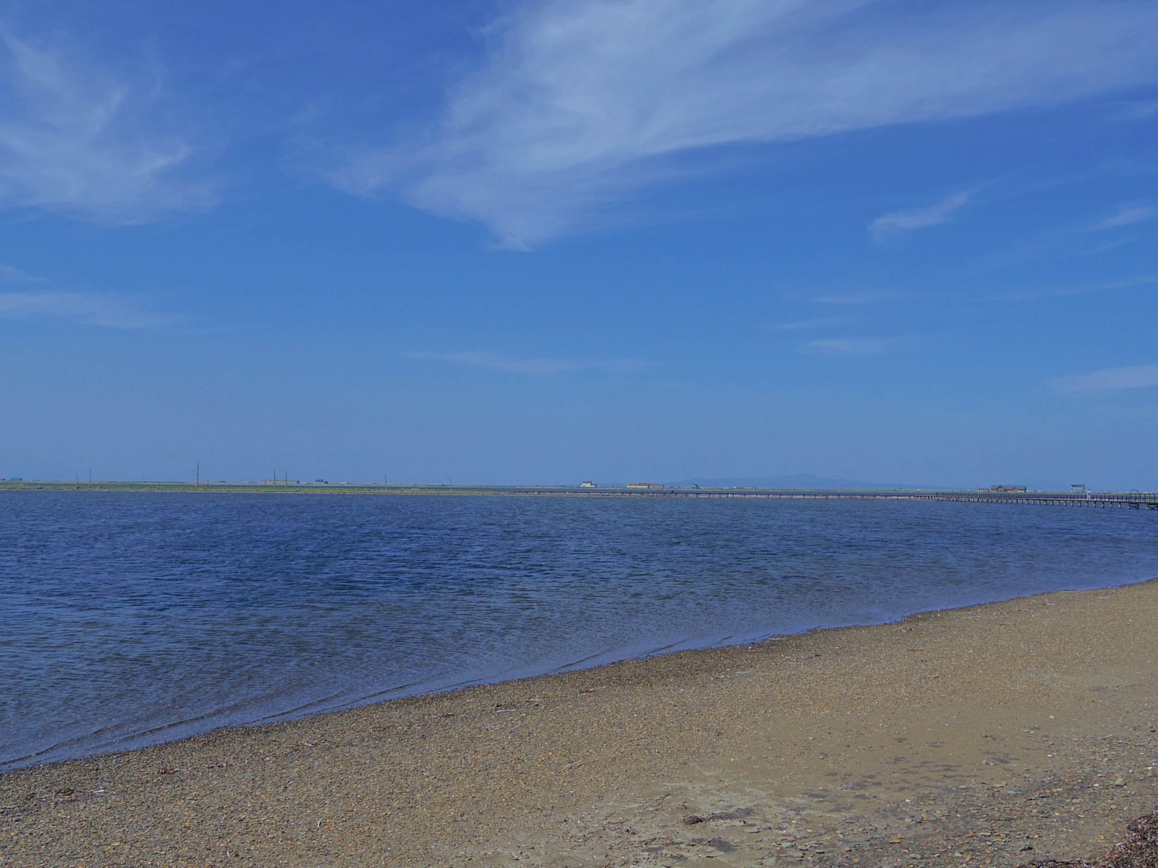 Paesaggio costiero con cielo blu e superficie d'acqua calma