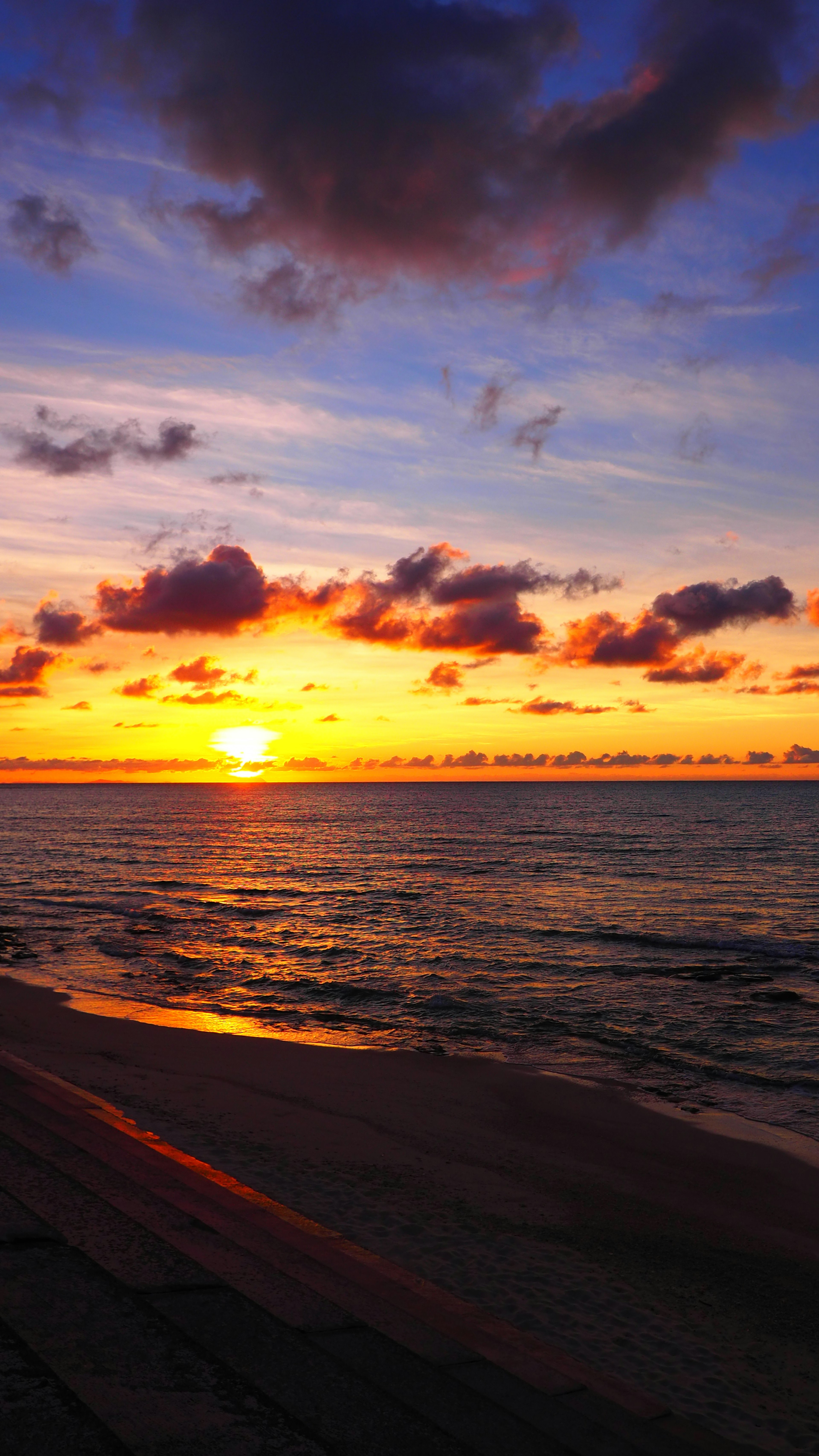 Un beau coucher de soleil sur l'océan avec des nuages colorés