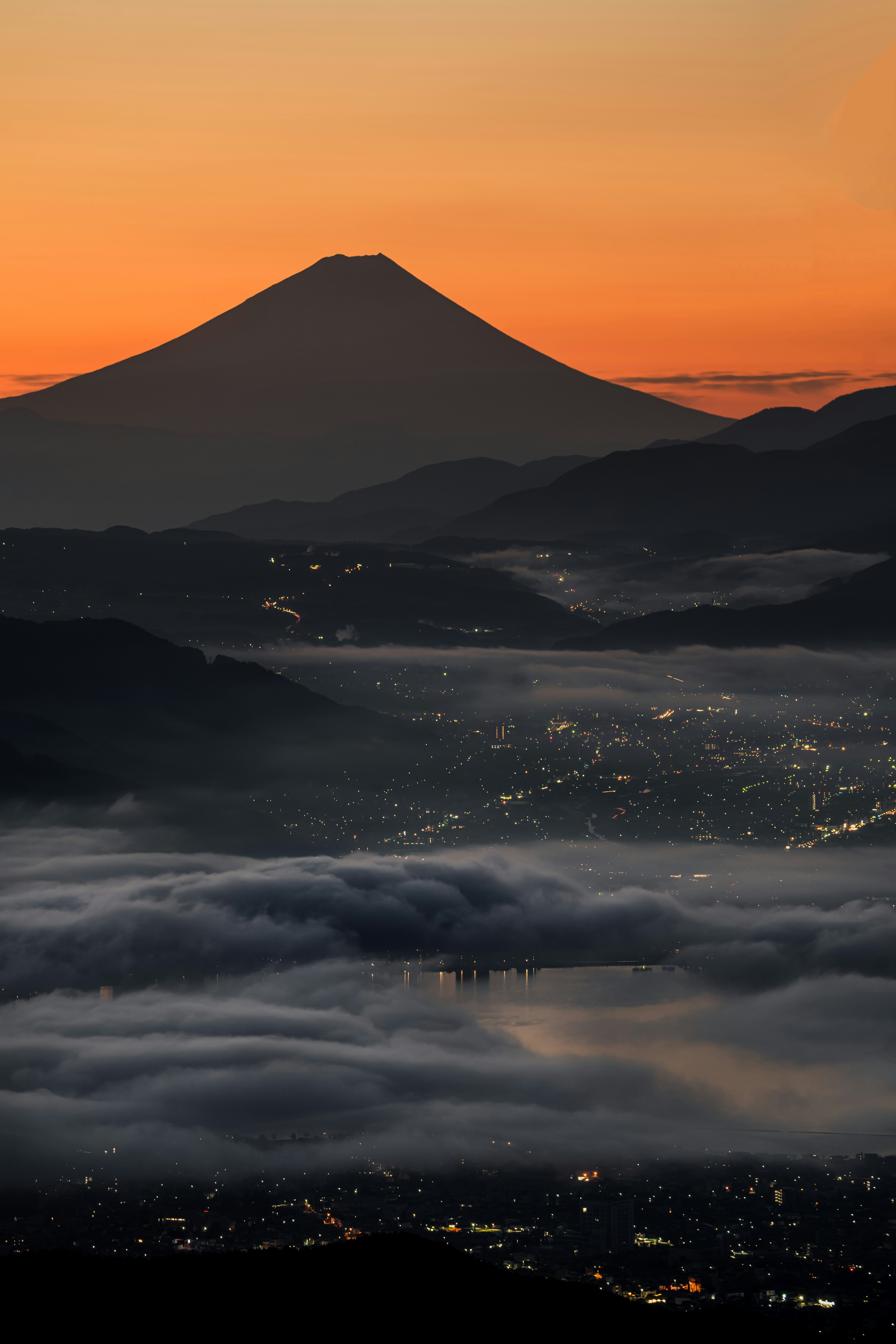 富士山と夕焼けの美しい風景雲海に浮かぶ街の明かり