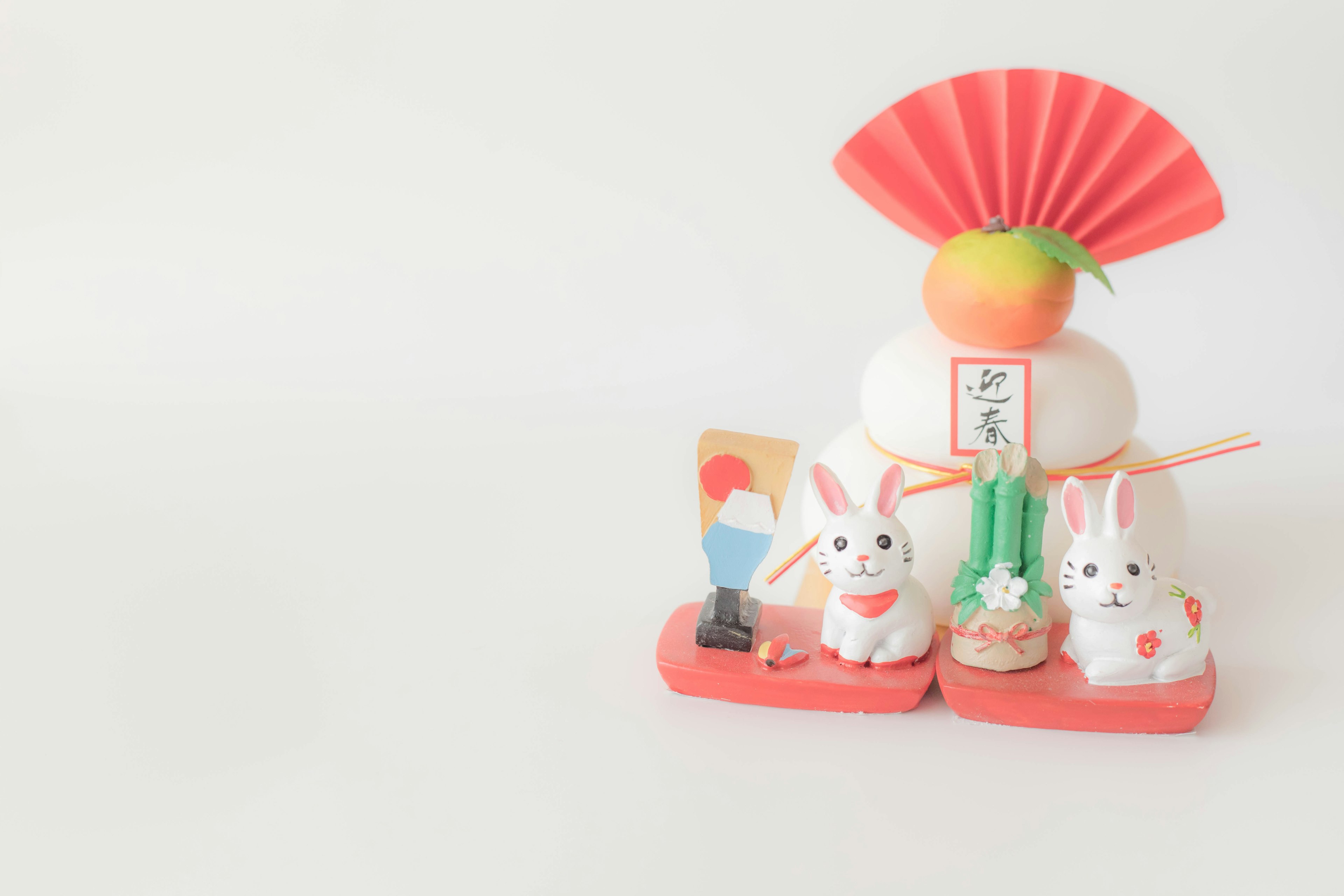 Décoration traditionnelle japonaise du Nouvel An avec des figurines de lapins et un éventail sur fond blanc