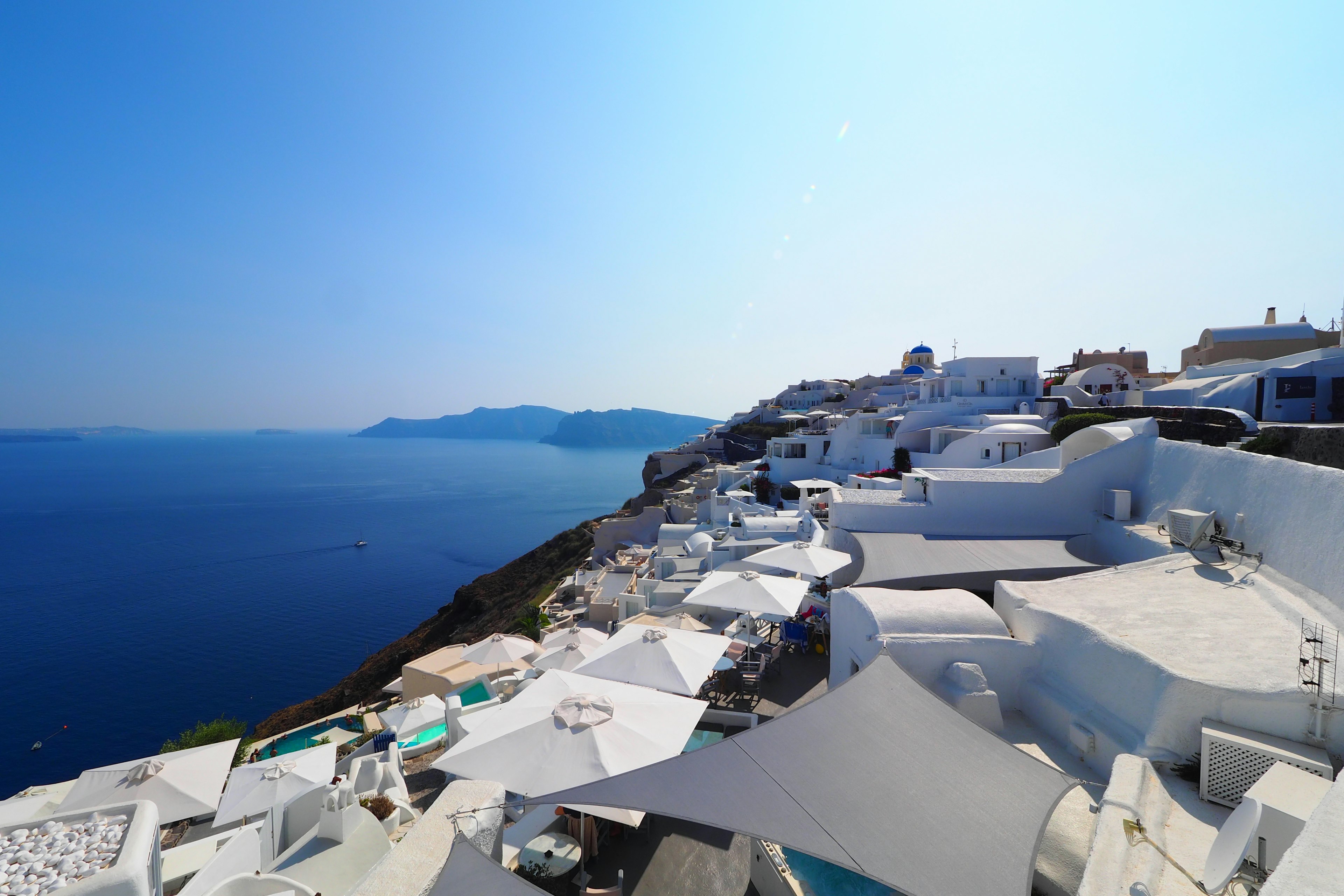 Paisaje de Santorini con edificios blancos que miran al mar y al cielo azules