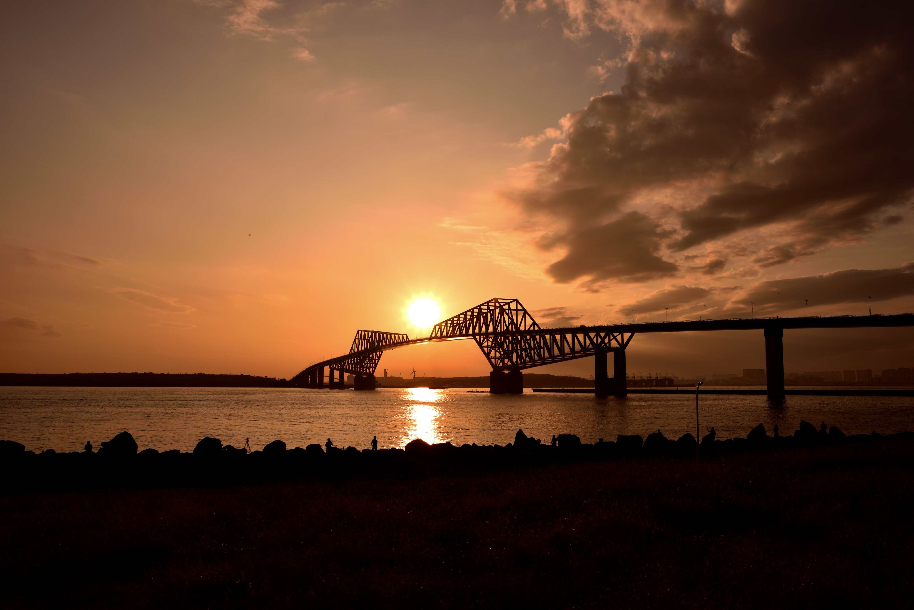 Silhouette di un ponte al tramonto con riflessi sull'acqua