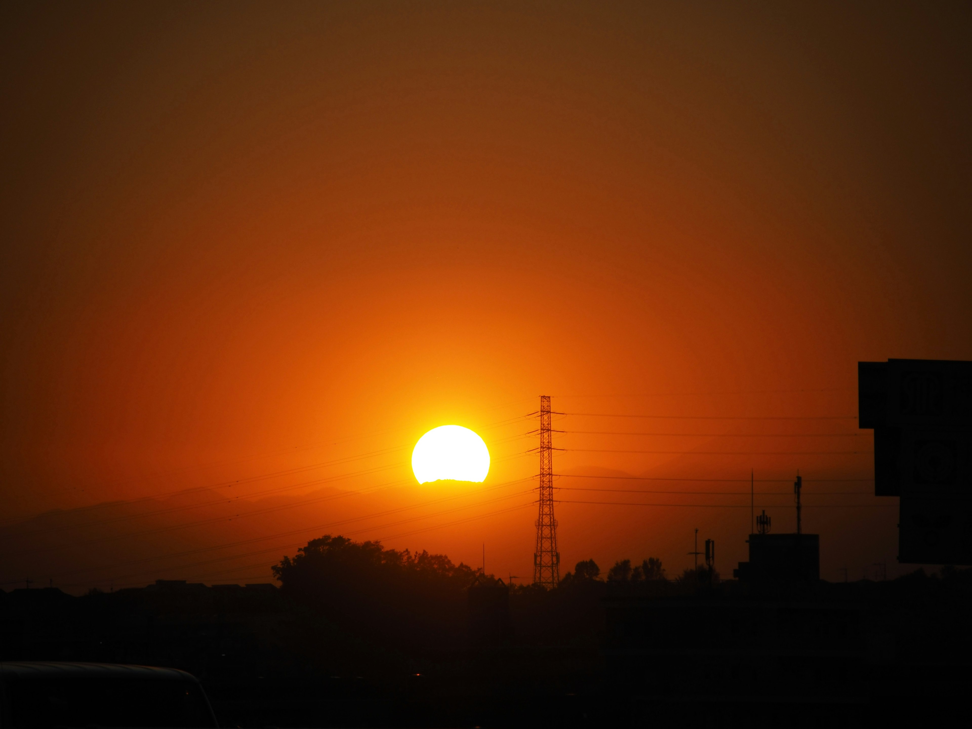 Un hermoso atardecer con el sol poniéndose en el horizonte y edificios en silueta