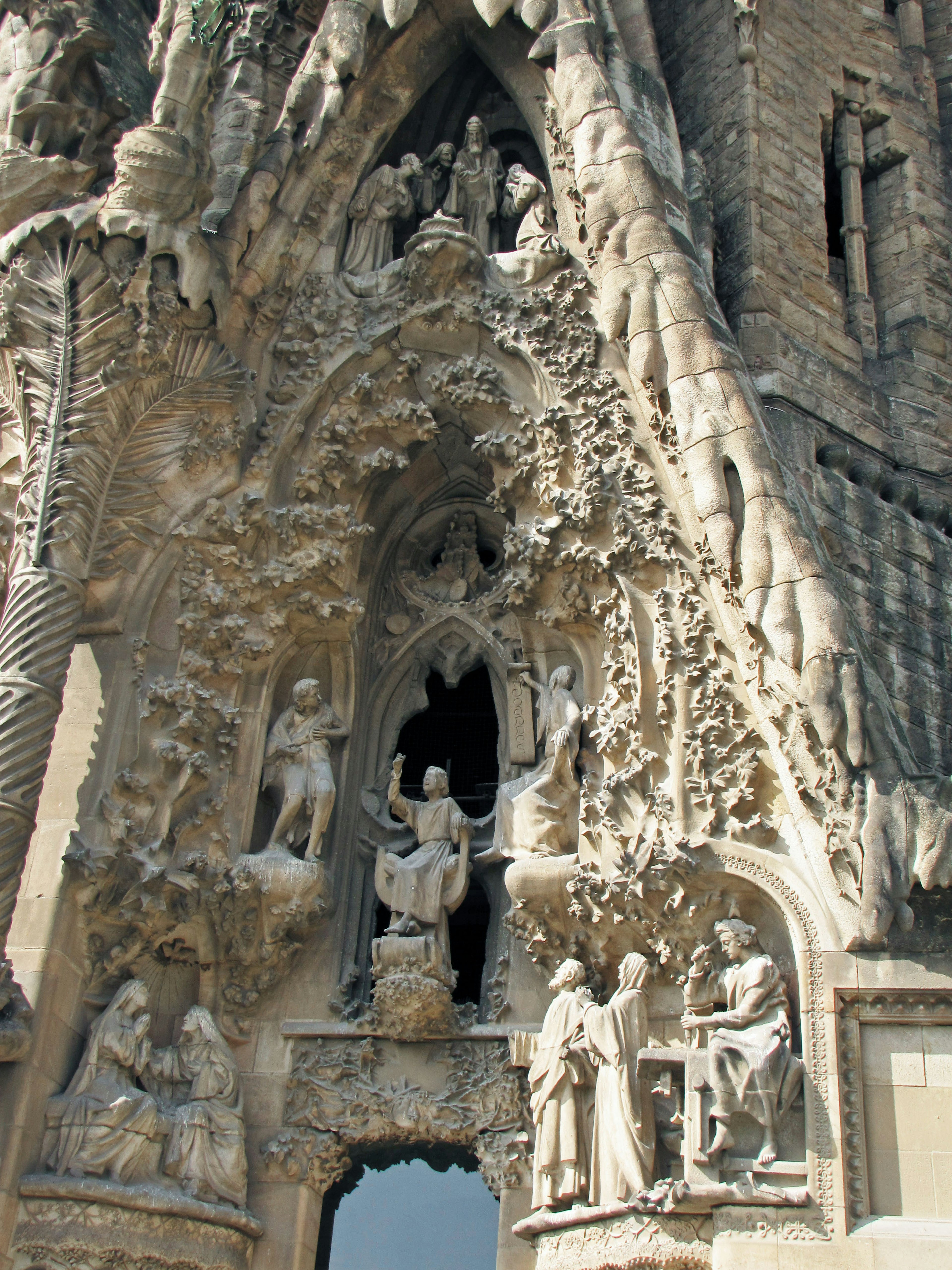 รายละเอียดของหน้าต่าง Sagrada Familia ที่มีการแกะสลักซับซ้อนของฉากและตัวละครทางศาสนา