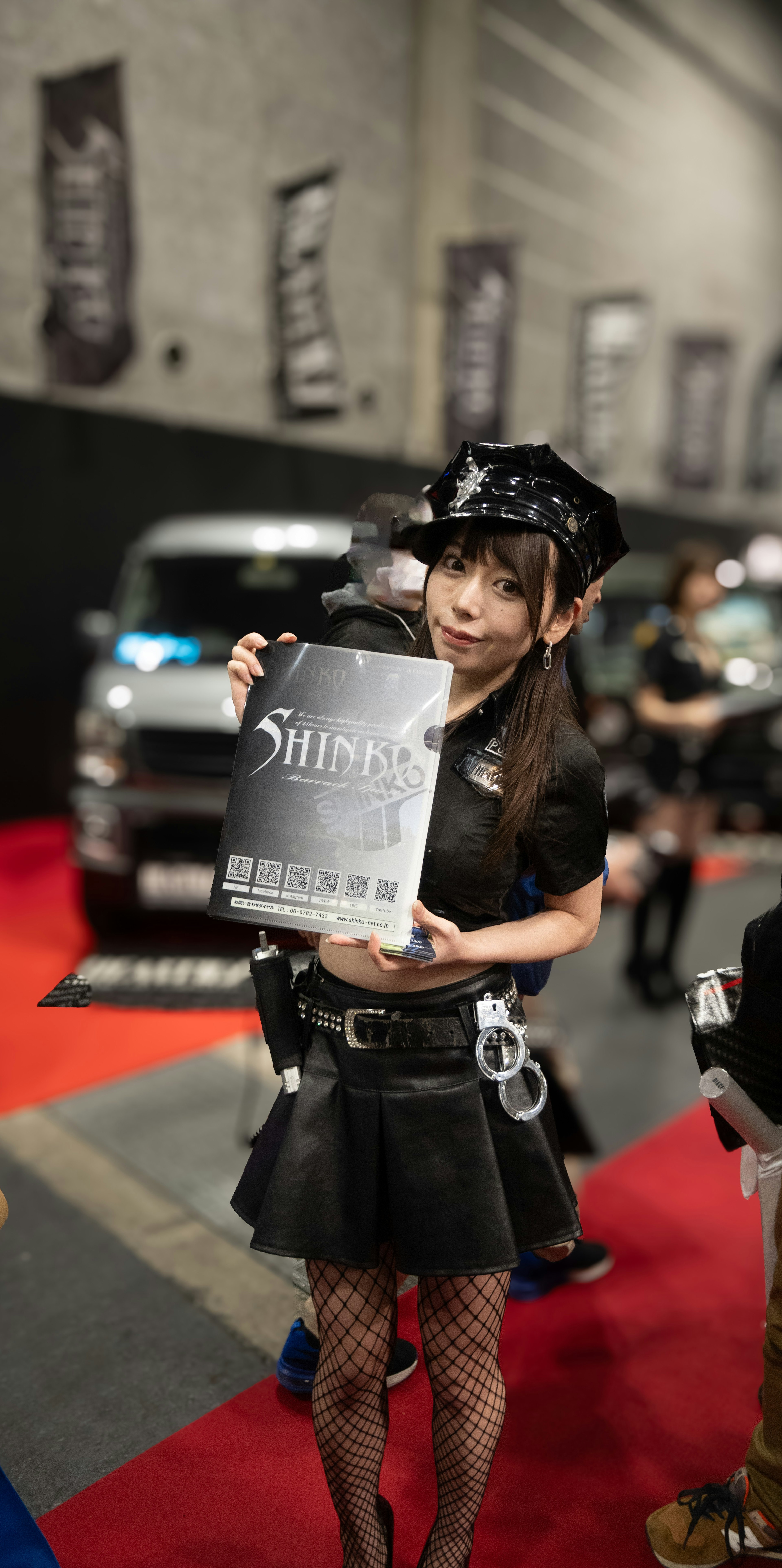 A cosplayer holding a sign on a red carpet