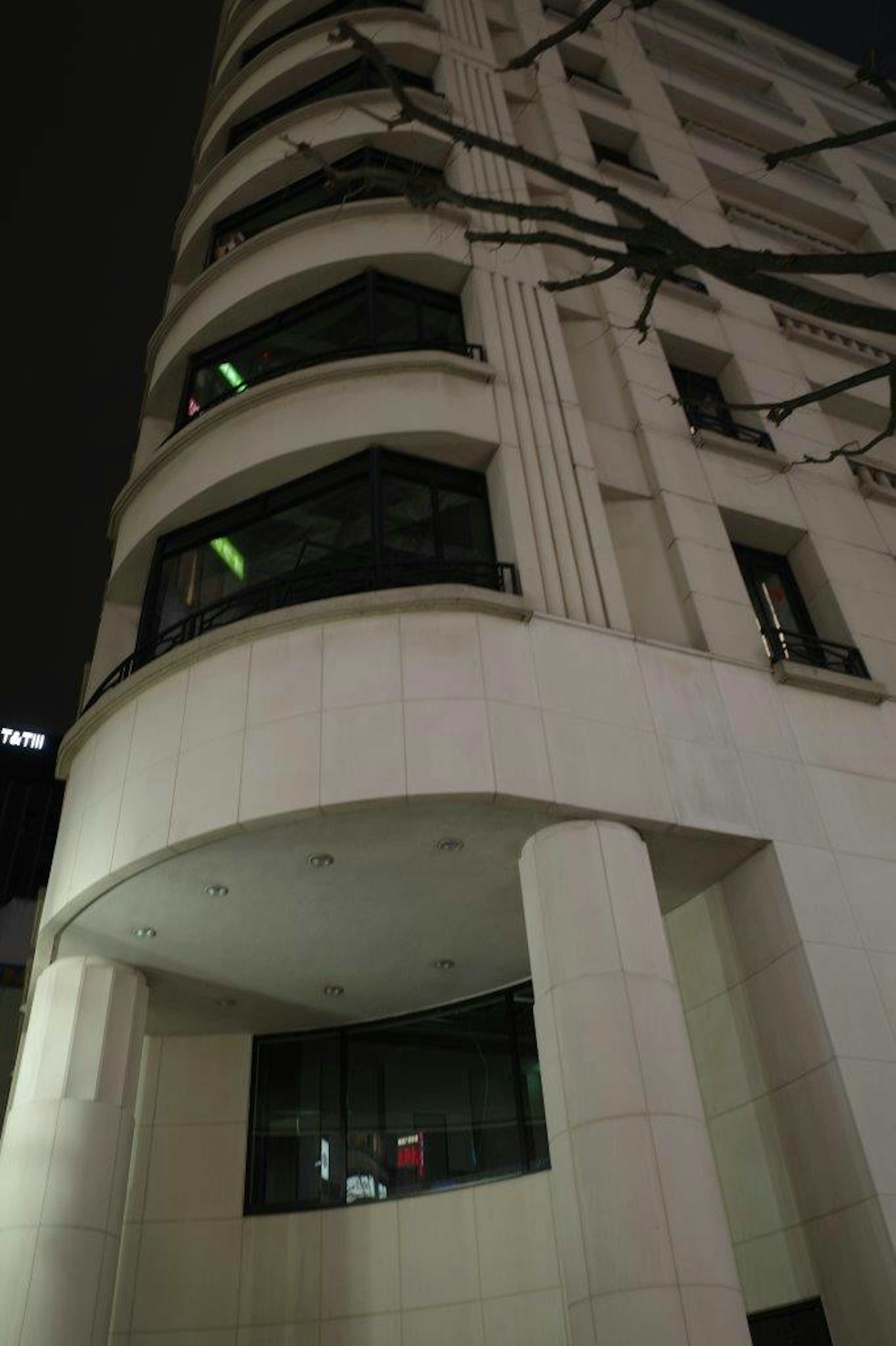 Corner of a modern building at night featuring unique lighting and architectural design