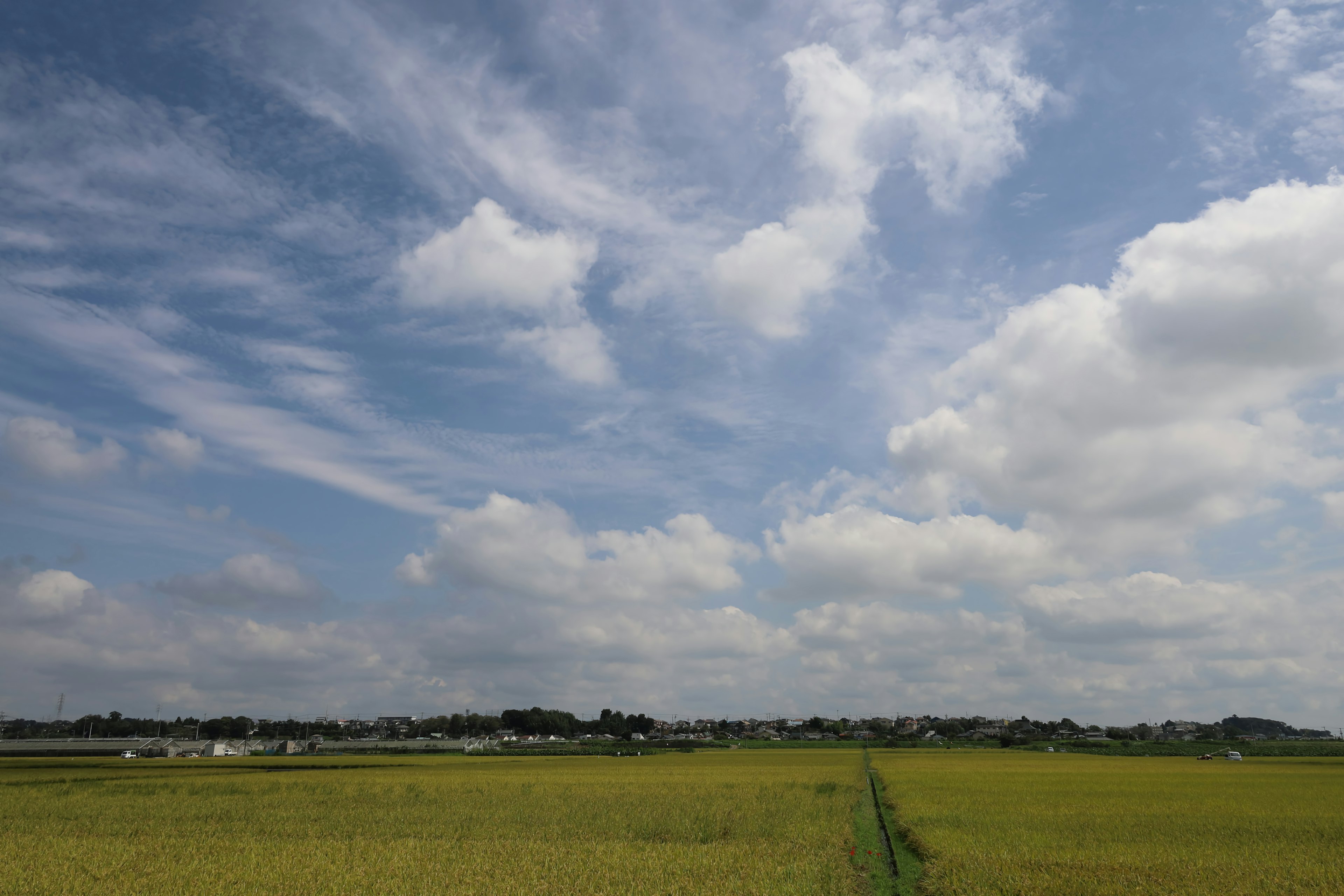 Landskap pedesaan dengan langit biru dan awan putih