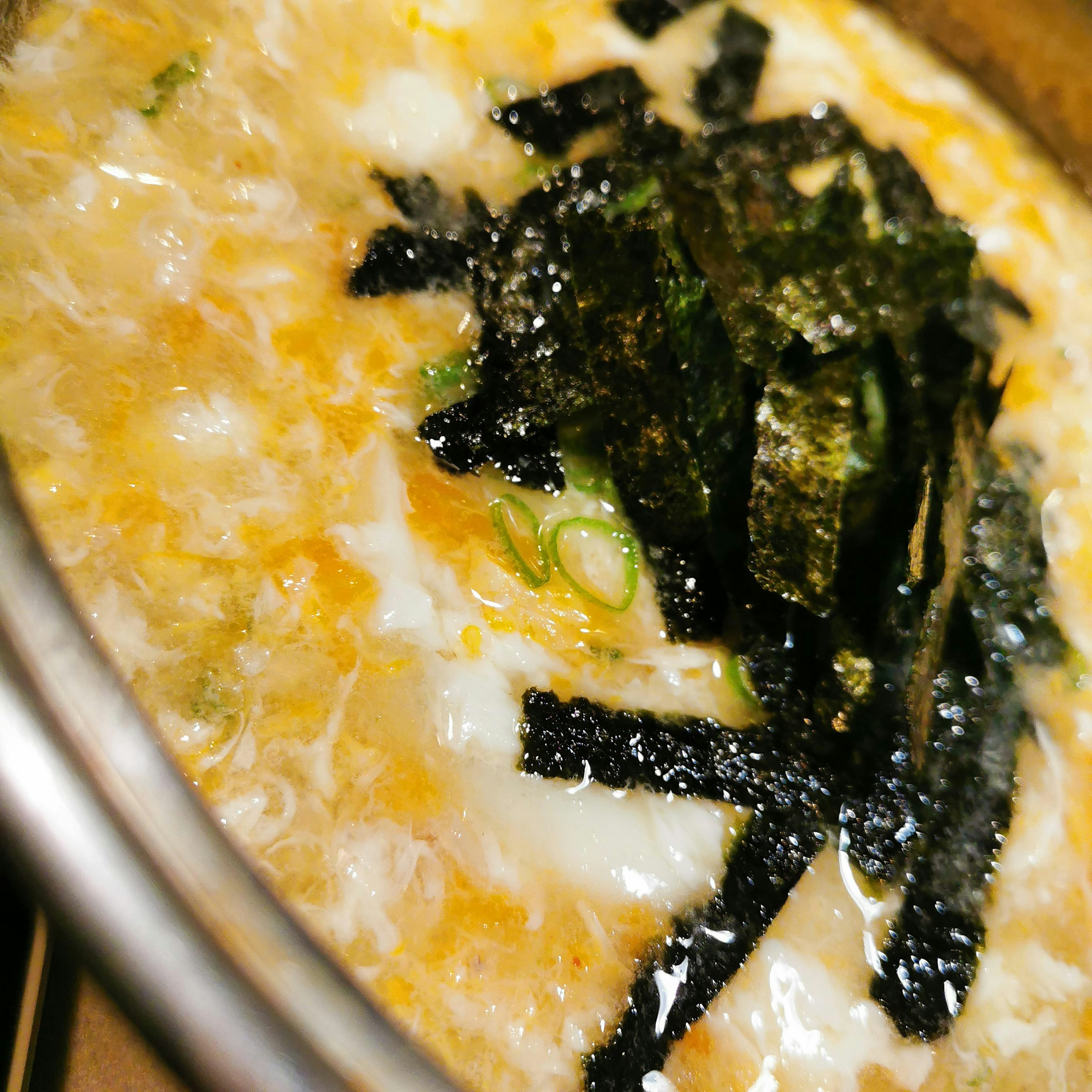 Close-up of egg and seaweed soup with vibrant colors