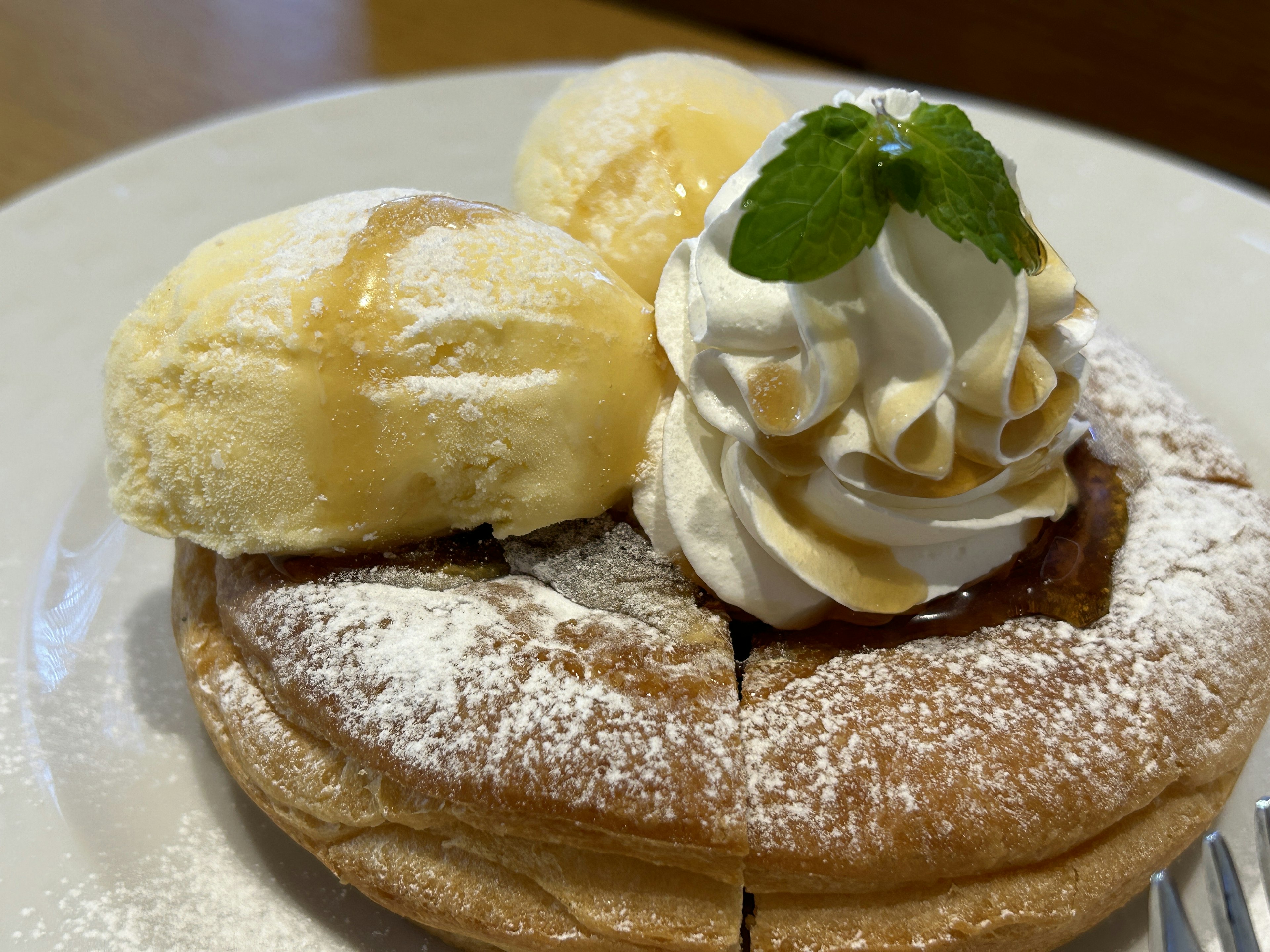 Panqueque esponjoso cubierto con crema batida y helado servido en un plato