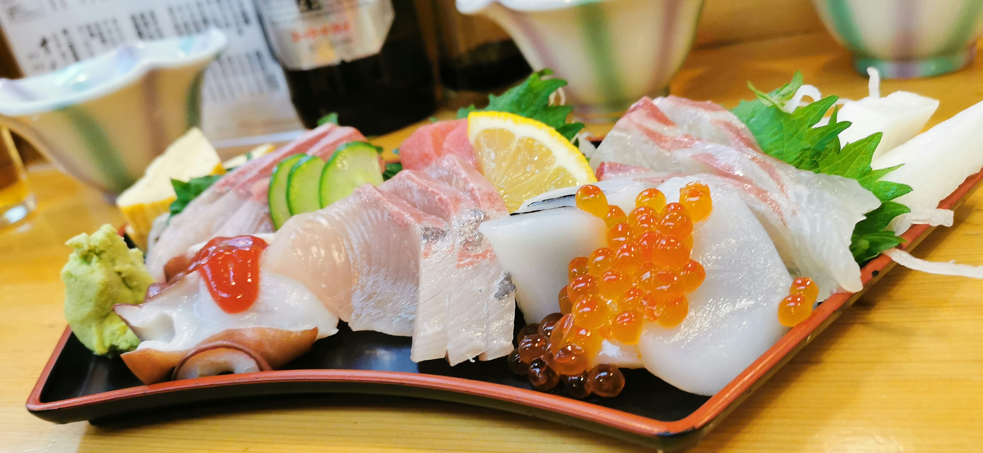 Piatto di sashimi con pesce assortito e fette di agrumi