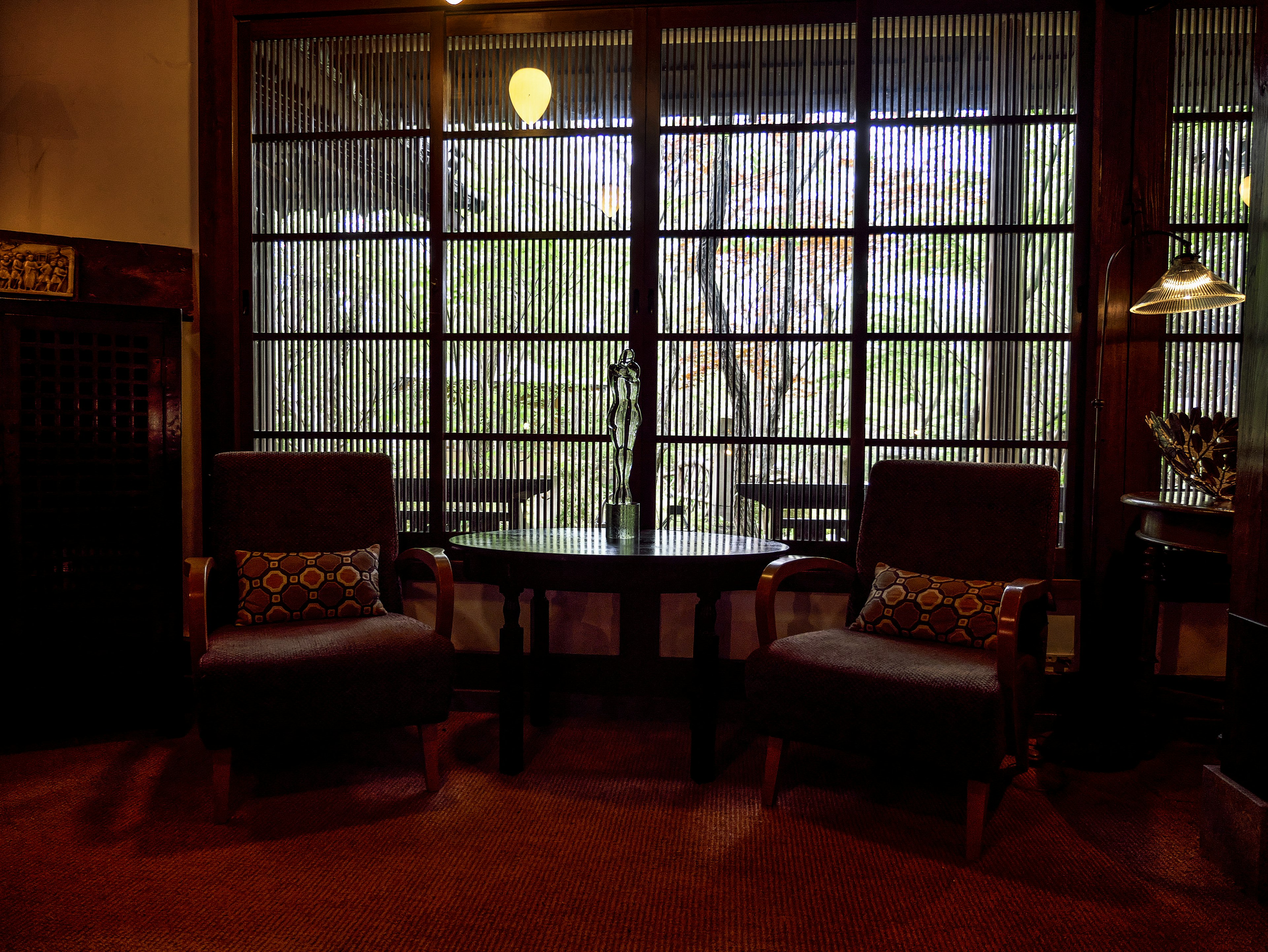 Espacio interior acogedor con dos sillas y una mesa con vista a un paisaje verde a través de la ventana