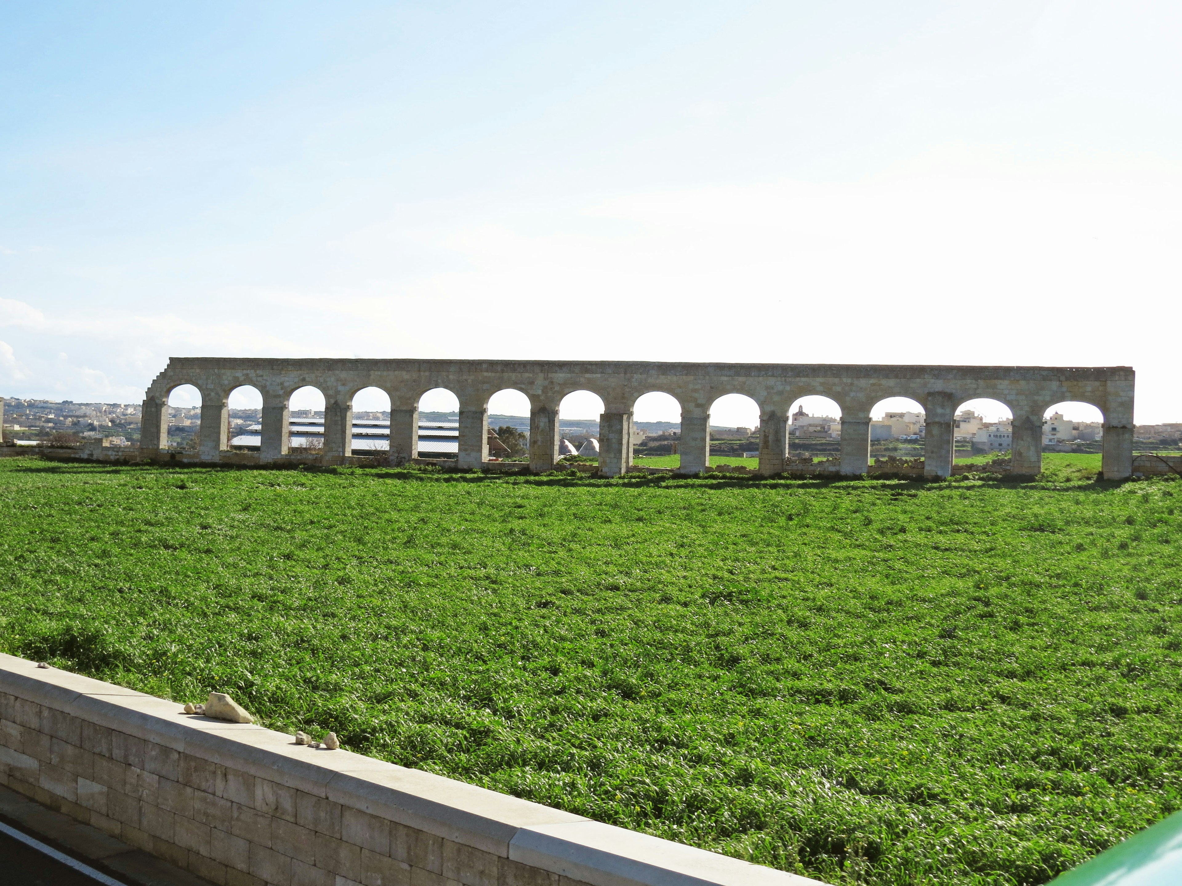 Ruinas de un acueducto antiguo en un campo verde