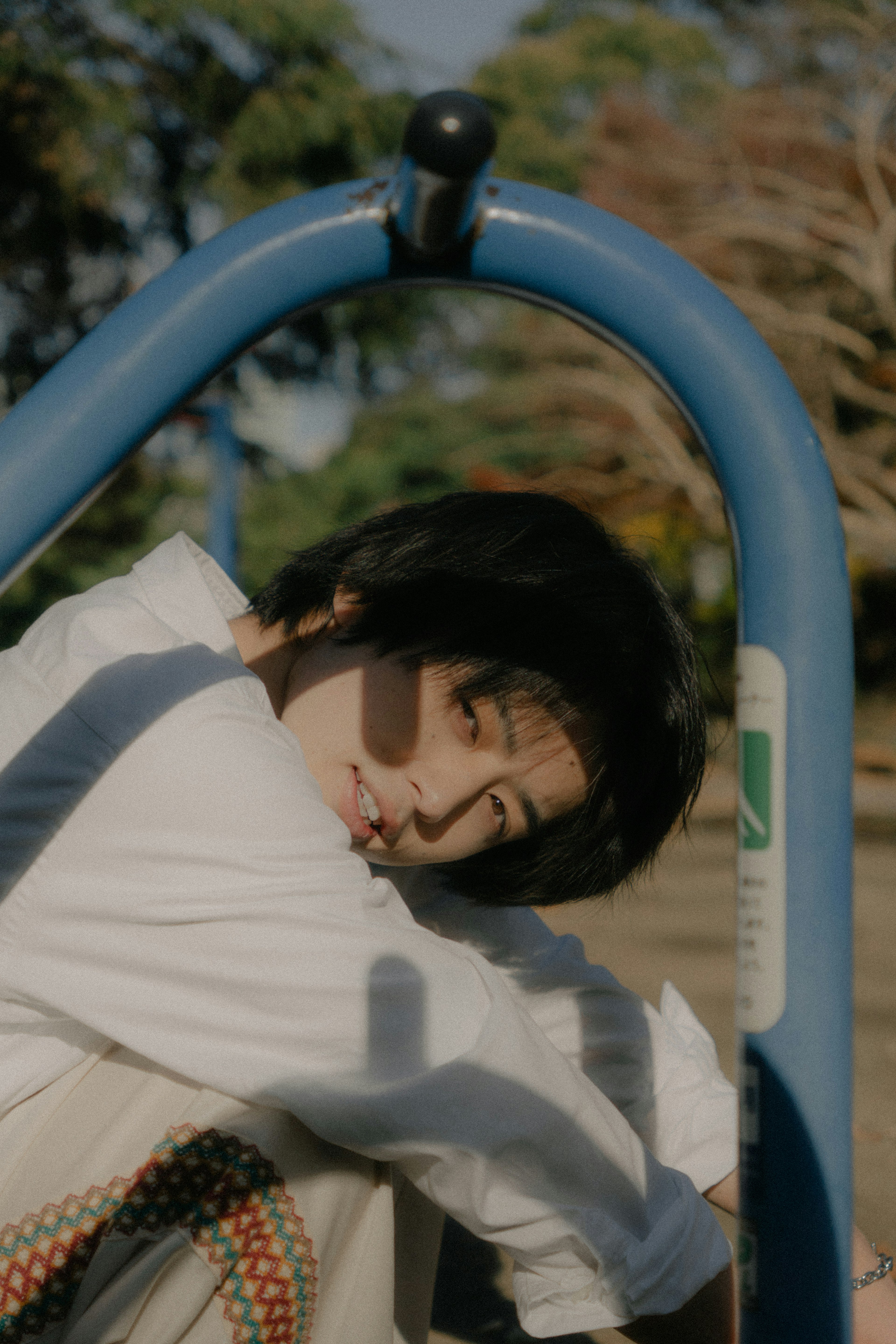 A young woman posing within a blue playground frame