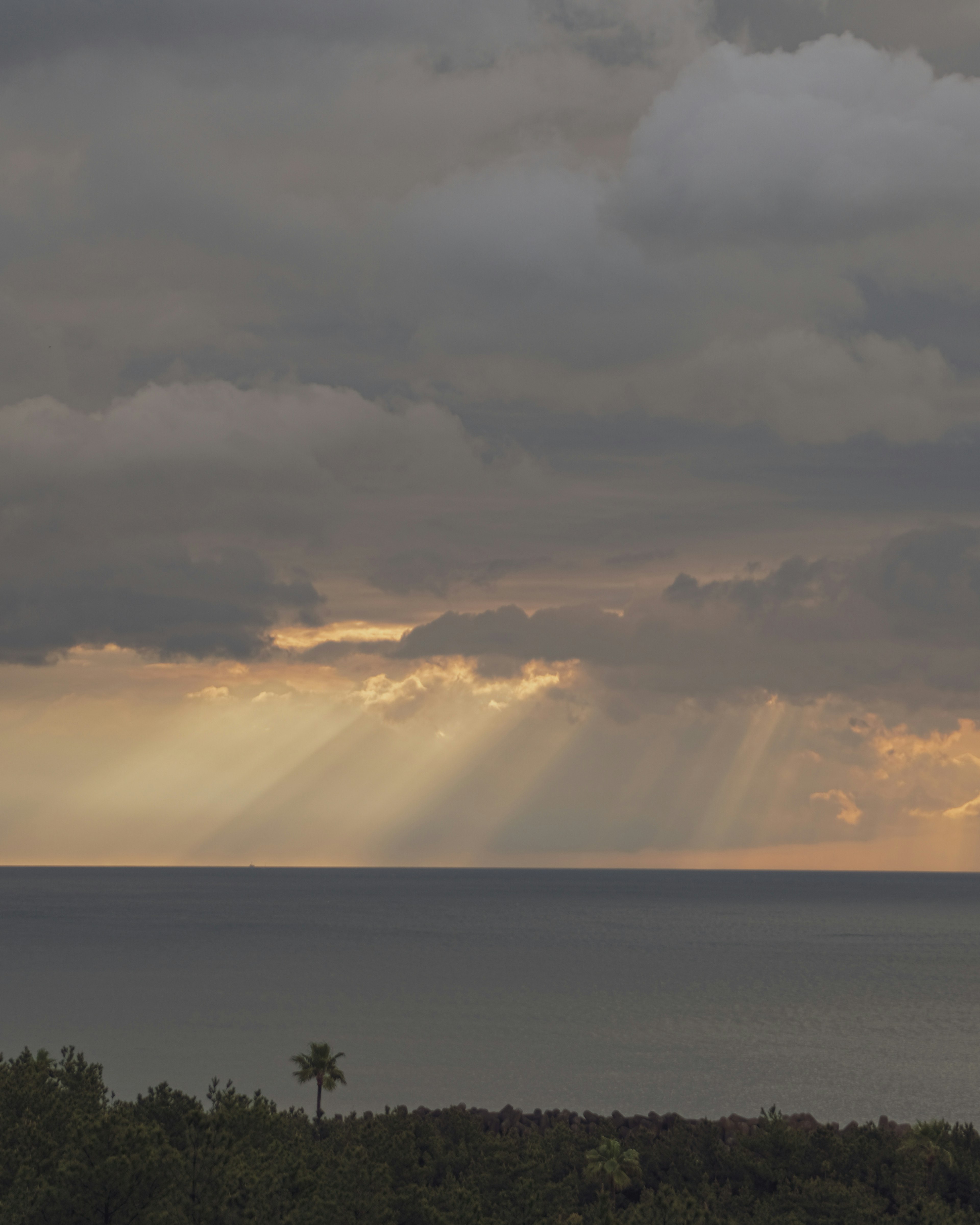 Ciel nuageux avec des rayons de lumière sur la mer